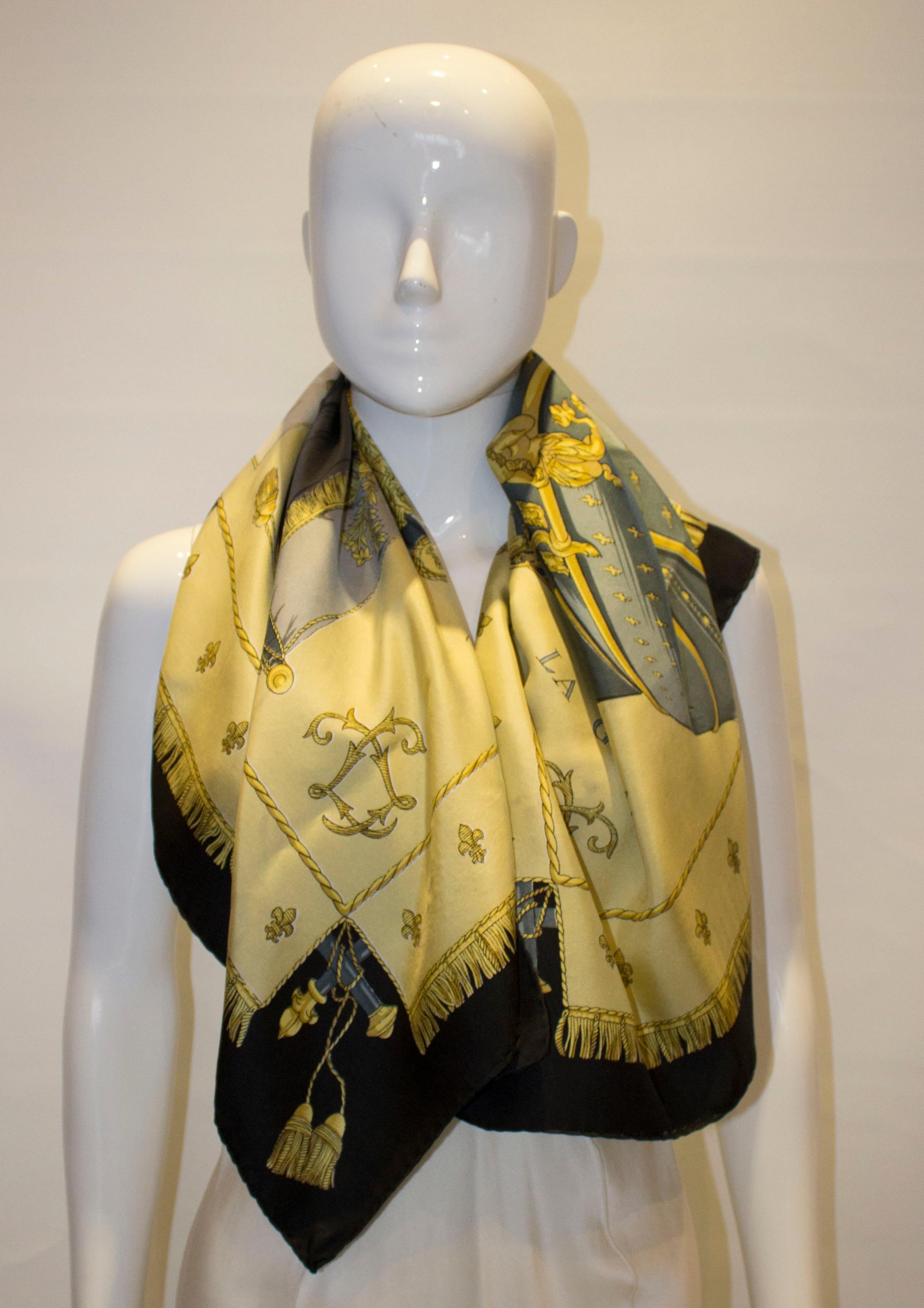 A vintage silk Hermes scarf designed by  Hugo Grygkar.  The scarf has a black border with a  gold , grey and blue design. Measurement 35'' x 35''.