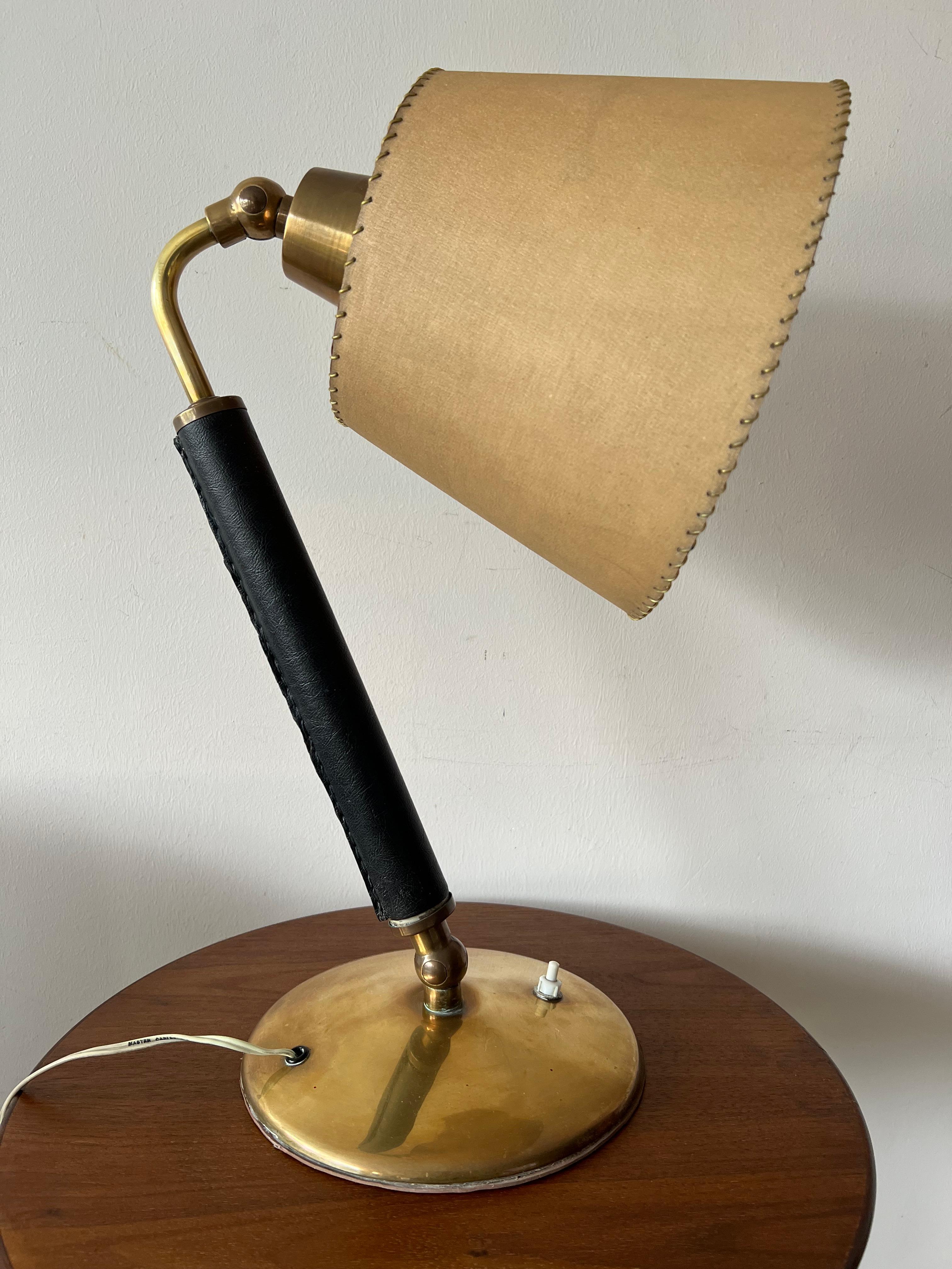 A modernist table lamp, leather in the style of Hermes.  Original parchment shade, polished brass base. Very nice vintage condition, ca' 1950's. The shade pivots and could be used as an uplight.