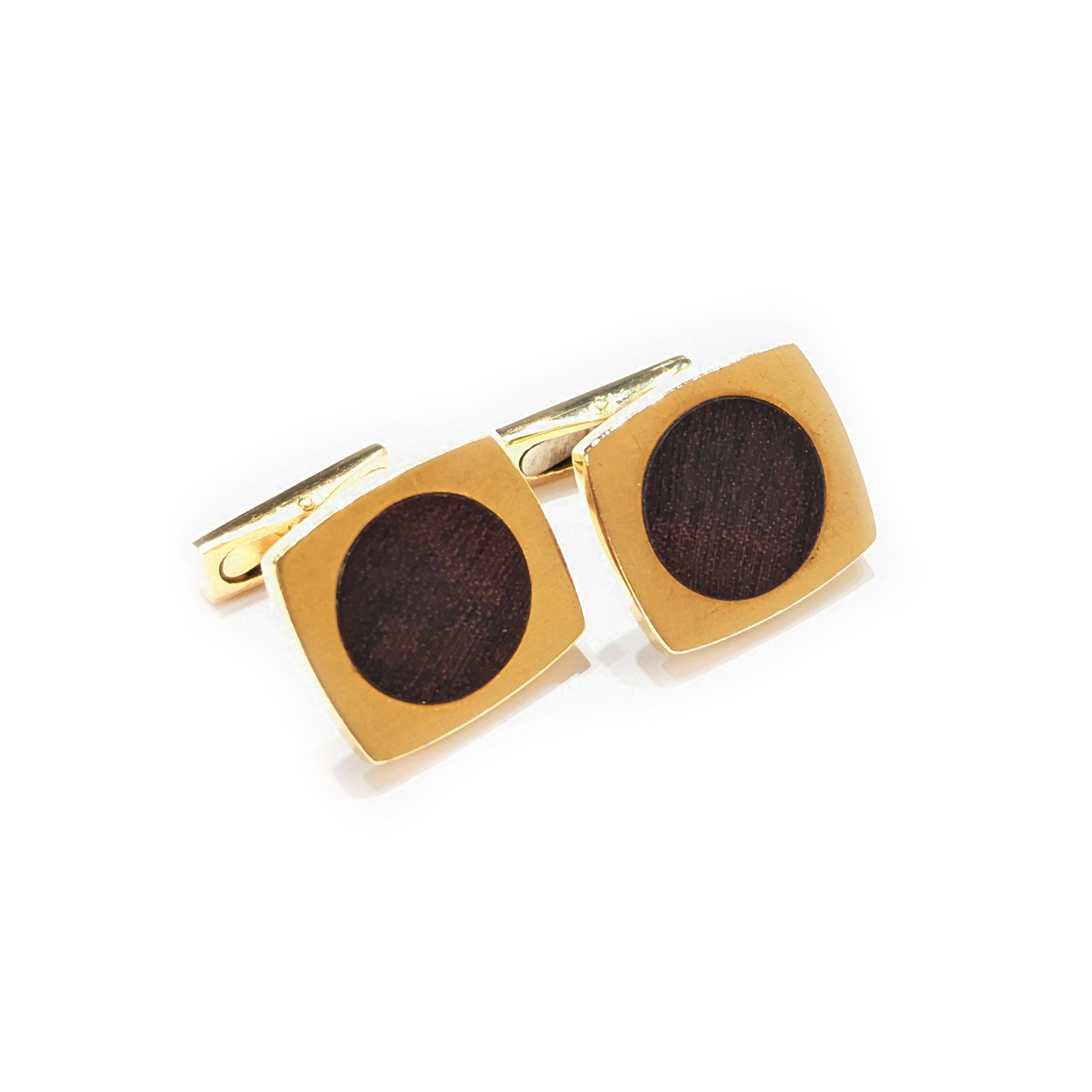 A pair of vintage Hermès wood and gold cufflinks, with teak wood discs set in gold curved sided rectangles, with bar fittings, with French eagle head marks for 18ct gold, signed HERMES Paris, numbered 6077and 6074, with a maker's mark Sté and LFV,
