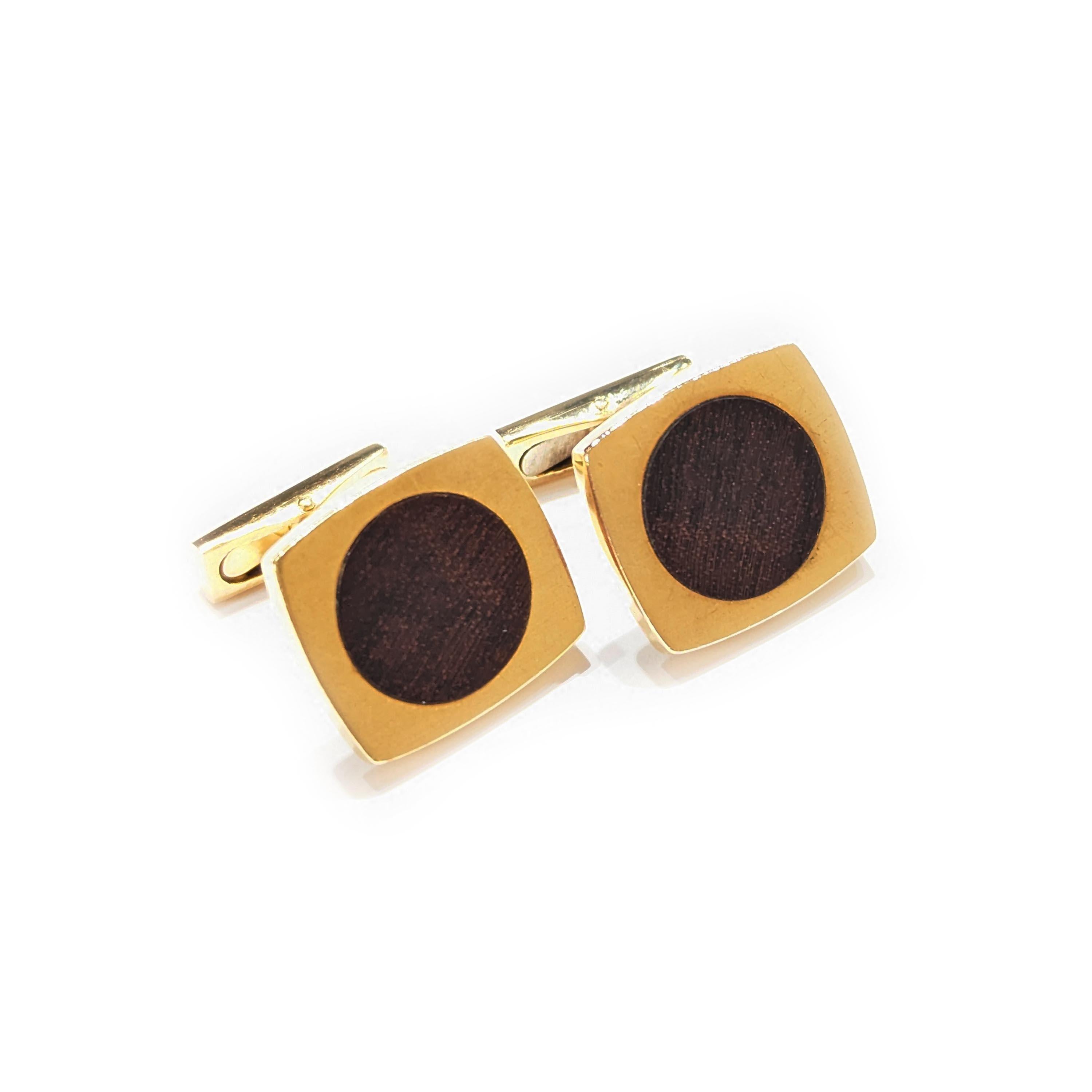Coppia di gemelli d'epoca in legno e oro di Hermès, con dischi in legno di teak incastonati in rettangoli d'oro dai lati curvi, con attacchi a barretta, con marchi francesi a testa d'aquila per l'oro 18ct, firmati HERMES Paris, numerati 6077 e 6074,