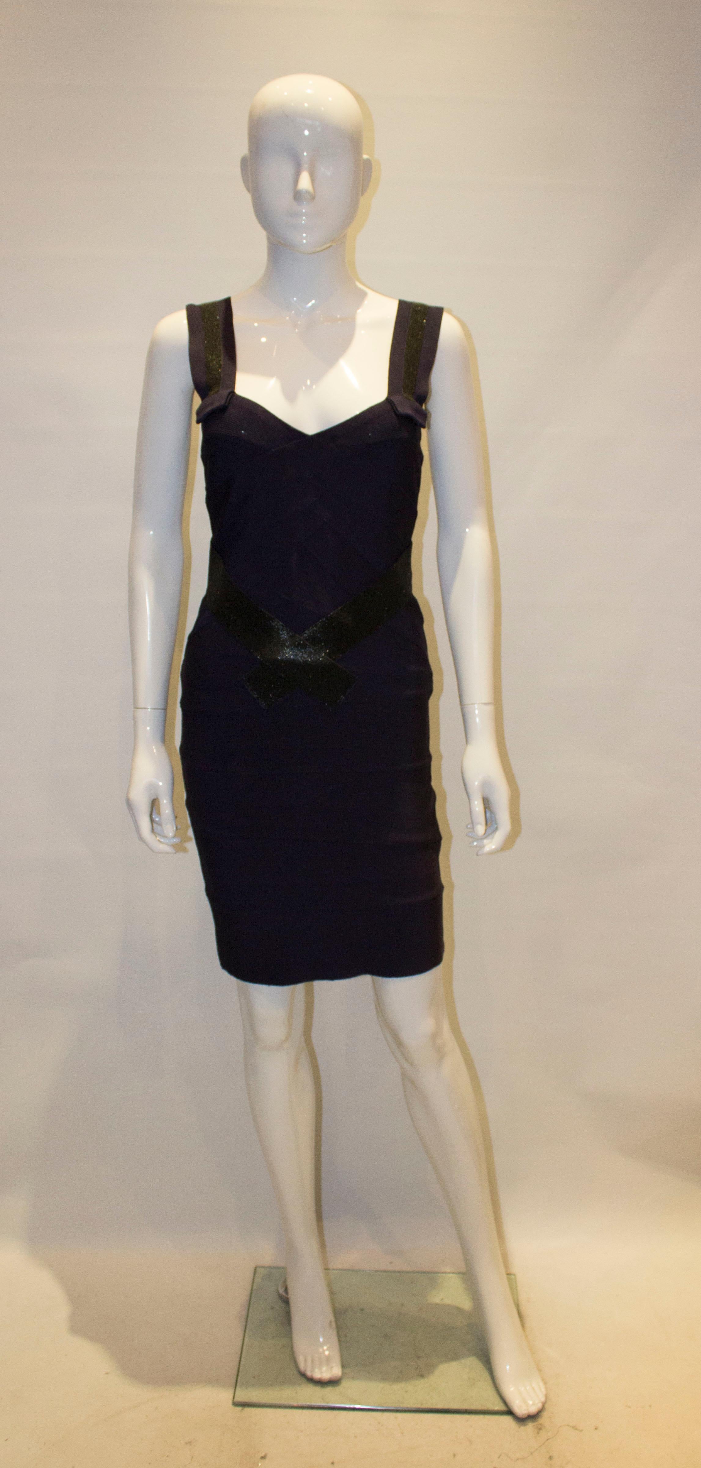 Une robe de cocktail chic signée Herve Leger. La robe est dans un joli  couleur aubergine foncé avec des détails scintillants noirs sur les bretelles, le devant et le dos.
Mesures : la robe est marquée taille S, buste 32'' avant stretch, taille