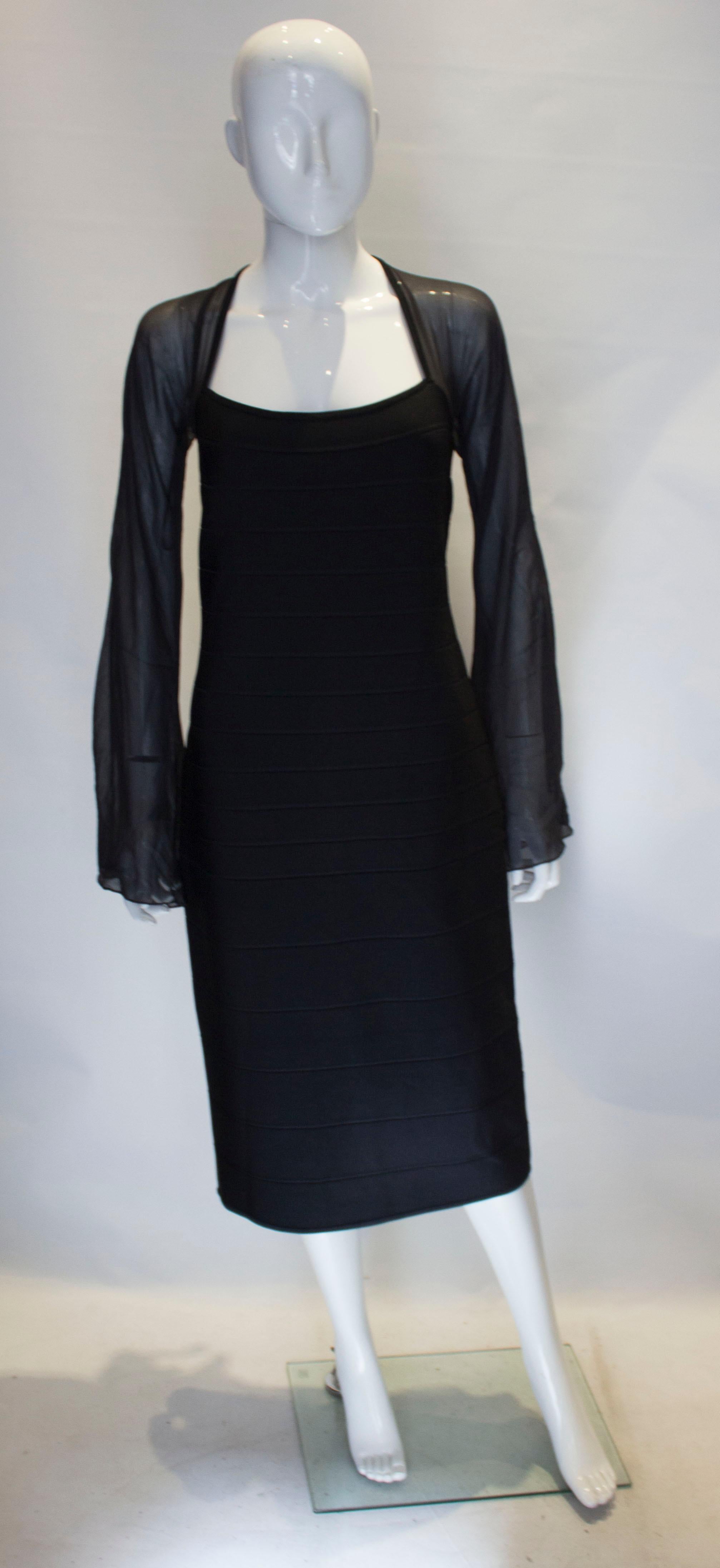 A chic Herve Leger dress  in black . This dress is unusual having long sleeves. It has a square neckline, and central back zip. The size has a some stretch.