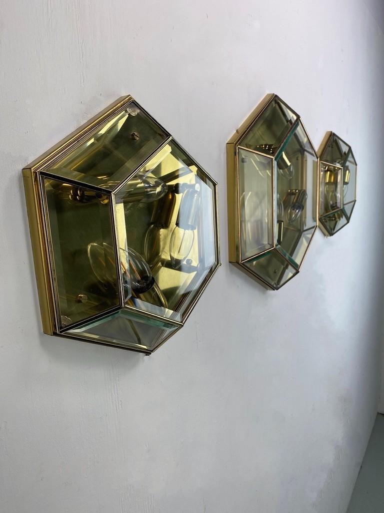 Stunning set of 3 hexagonal wall lamps. Qualitatively very nice and solidly made lamps as we are used to of German made products. A nice detail is the faceted edges which gives the lamp a luxurious look and it also radiates particularly beautifully