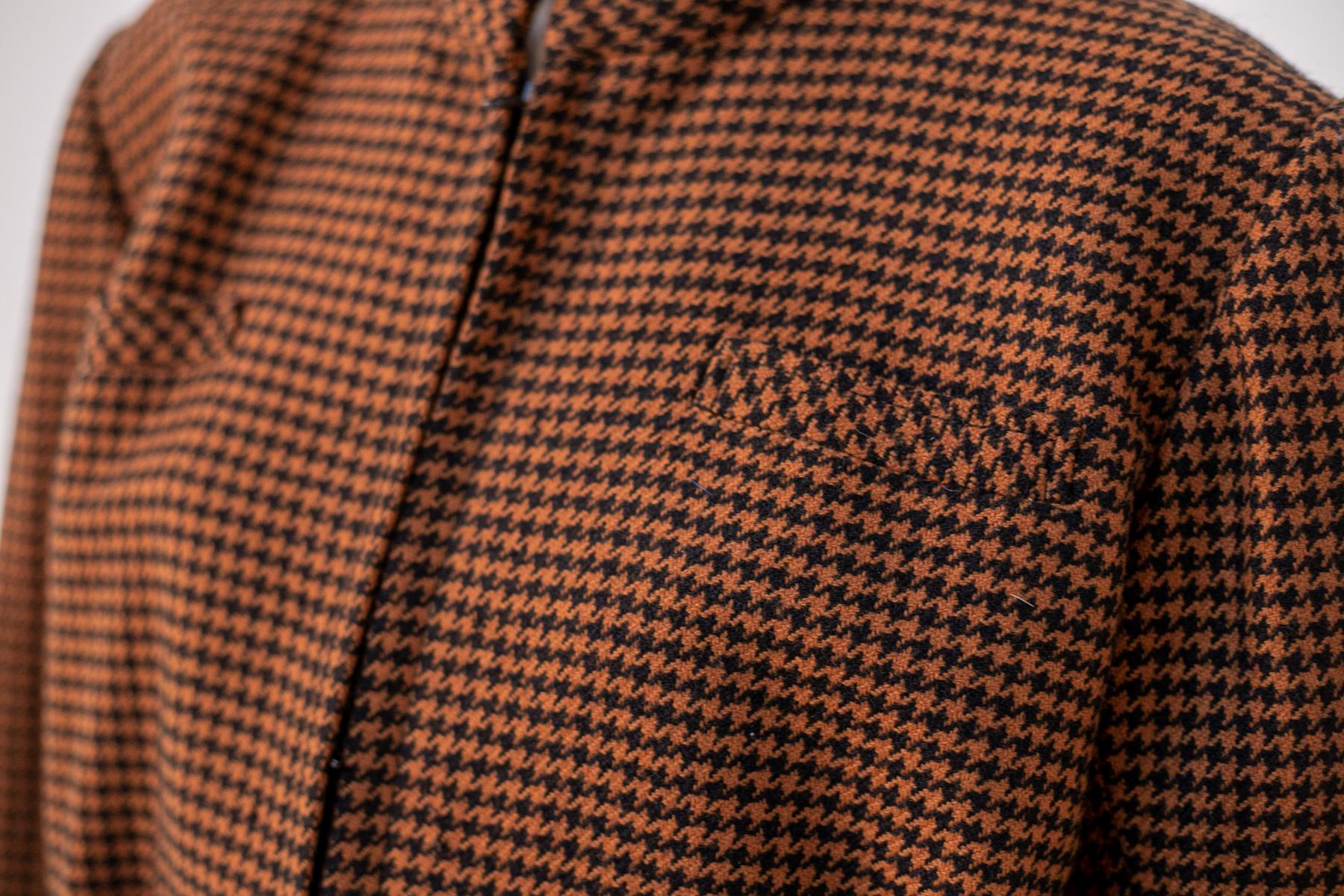 Whimsical vintage wool houndstooth jacket from the 1990s, made in Italy.
The jacket is totally made of orange and black wool, very soft, comes down to the waist. The collar is U-shaped compound. The sleeves are long, with high turned-up cuffs. The