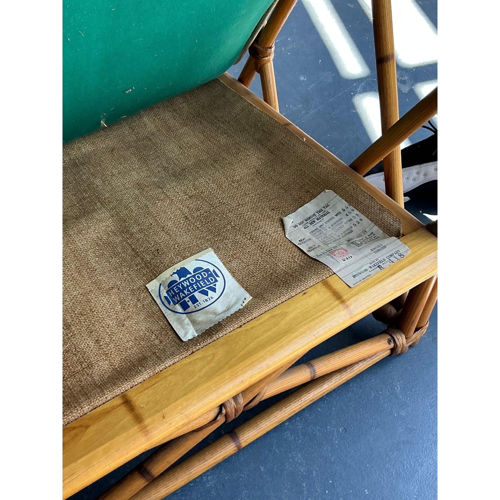Capture the iconic spirit of mid-century resort style with this exquisite vintage lounge chair by the celebrated American maker, Heywood Wakefield. The chair's frame is a sculptural masterpiece of bent rattan, featuring the signature 