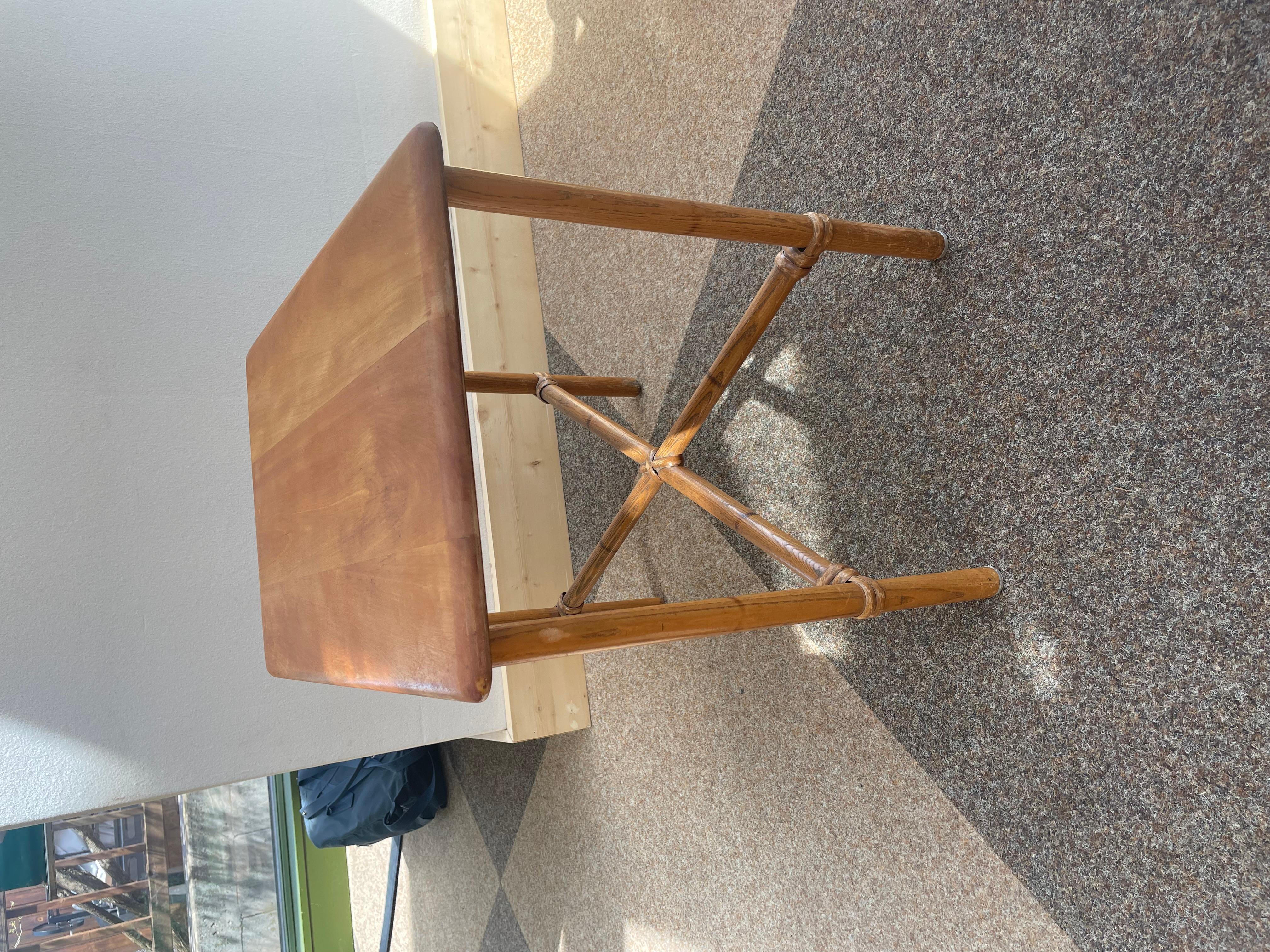 Cette charmante table d'appoint en rotin du milieu du siècle, créée par Eleg, illustre le savoir-faire et l'élégance décontractée qui ont défini le modernisme tropical américain dans les années 1940. Dotée d'un plateau en bois dur façonné à la main