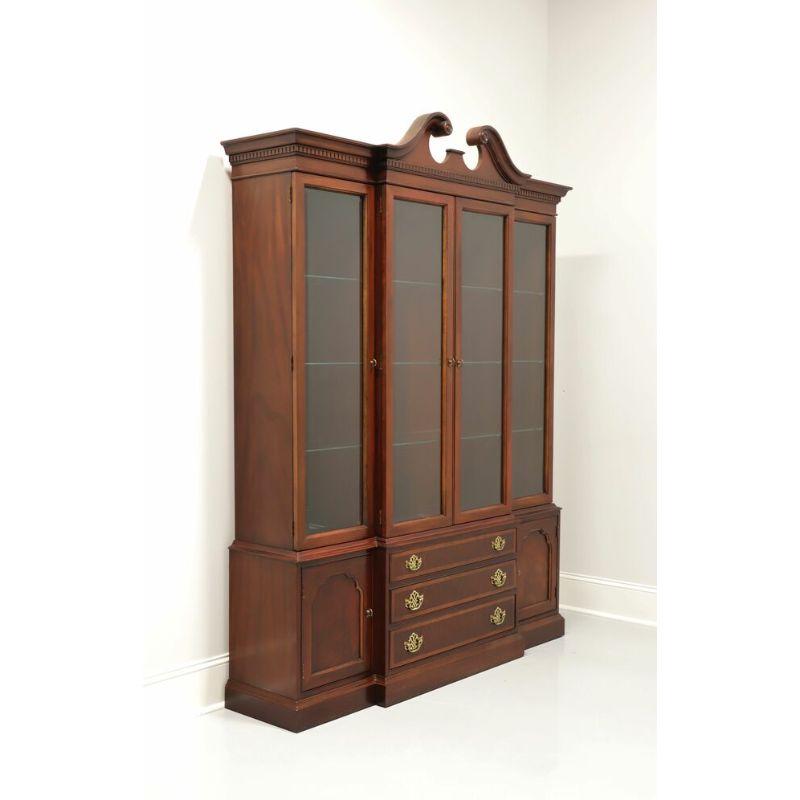 A Chippendale style breakfront china cabinet by Hickory Furniture, from their American Masterpiece Collection. Mahogany with banded drawer fronts and brass hardware. Top cabinet is lighted and has nine adjustable plate grooved glass shelves behind