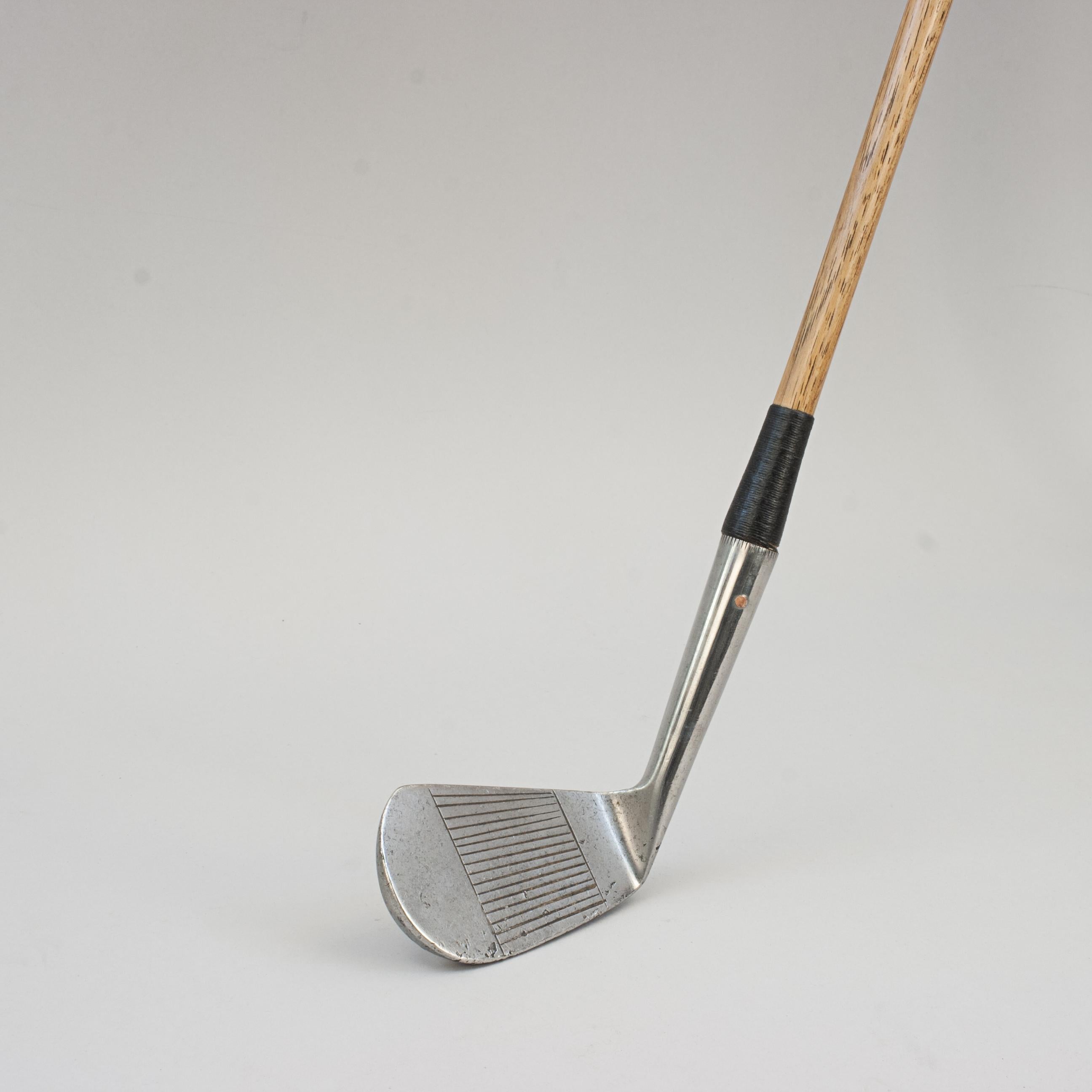 Gamage Mashie, Hickory Golf Club.
A good looking deep faced Mashie retailed by A.W. Gamage Ltd. The hickory shaft with a polished leather grip, the club head is stamped 'Warranted Hand Forged, Made In Scotland, A.W. Gamage Ltd., Special, Rustless,