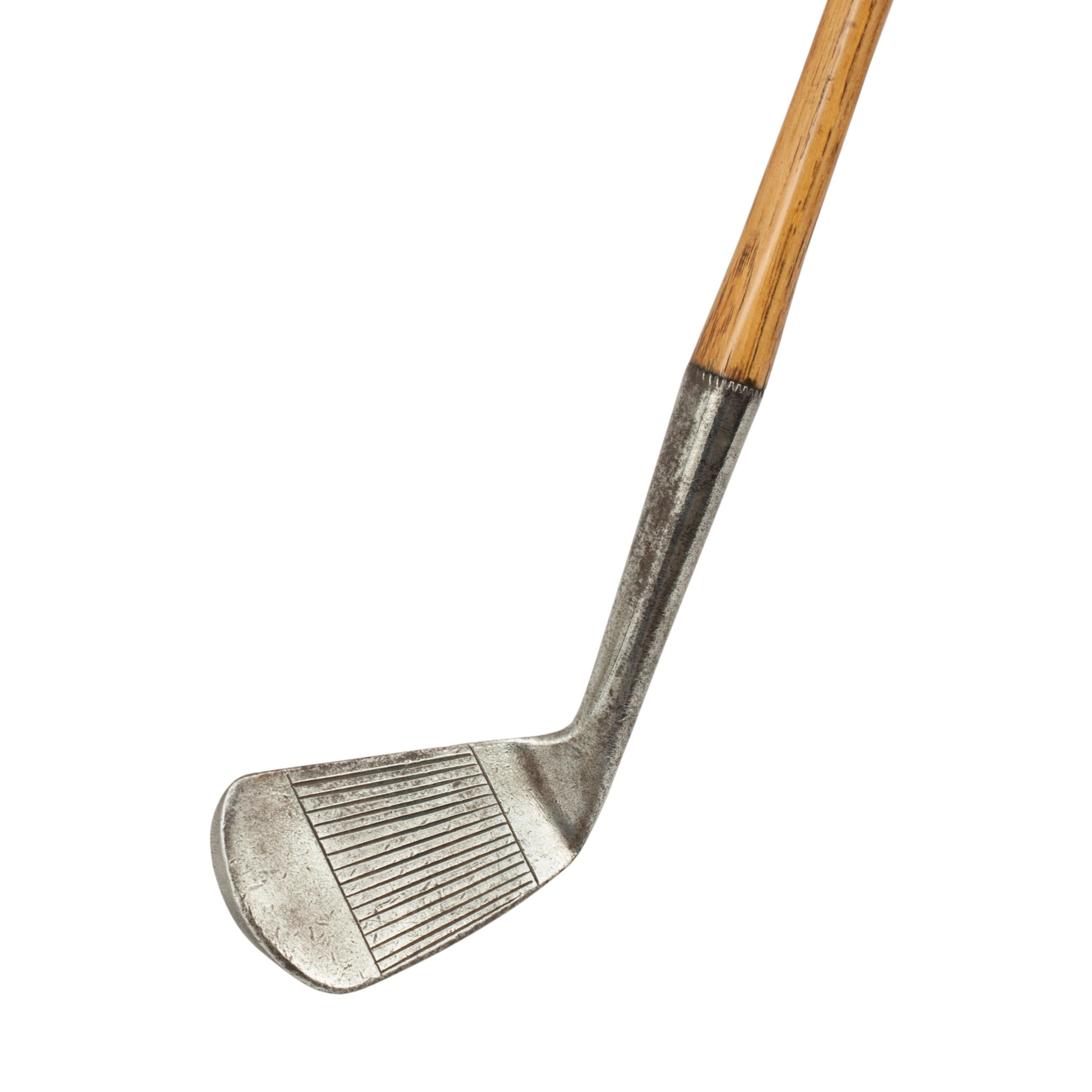Vintage Hickory Golf Club, Mashie, by Tom Stewart, St Andrews.
A fine and nicely weighted line faced mashie by Tom Stewart of St. Andrews. The hickory shaft with polished leather grip with the rear of the club head marked with Stewart's 'PIPE'
