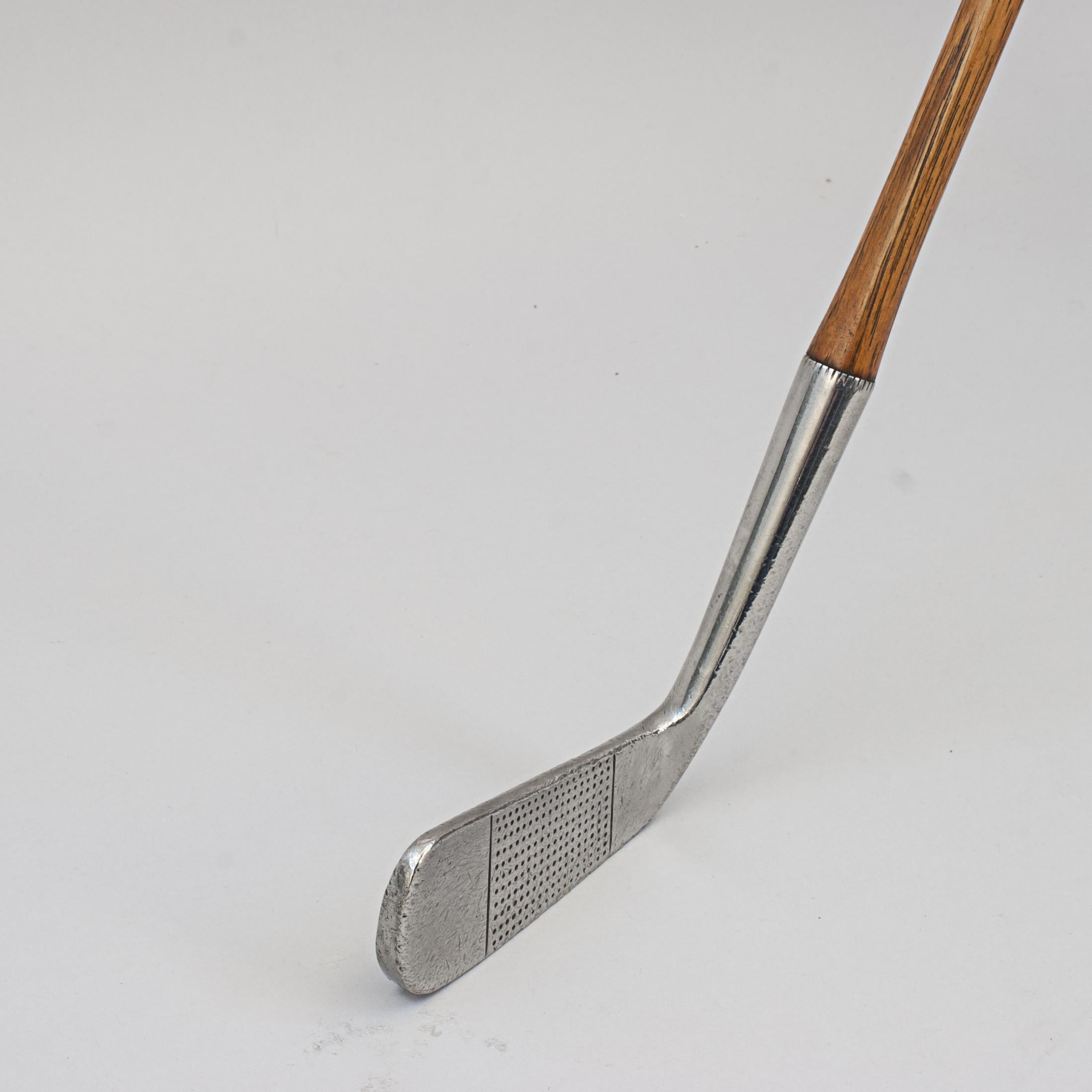 Hickory Golf Club, Blade Putter, The Knole.
Unusual bar backed hickory putter by Cyril Fryers, The Knole. The golf club with hickory shaft, suede leather grip, club face with dot punched face markings. The rear with extra weight across the center