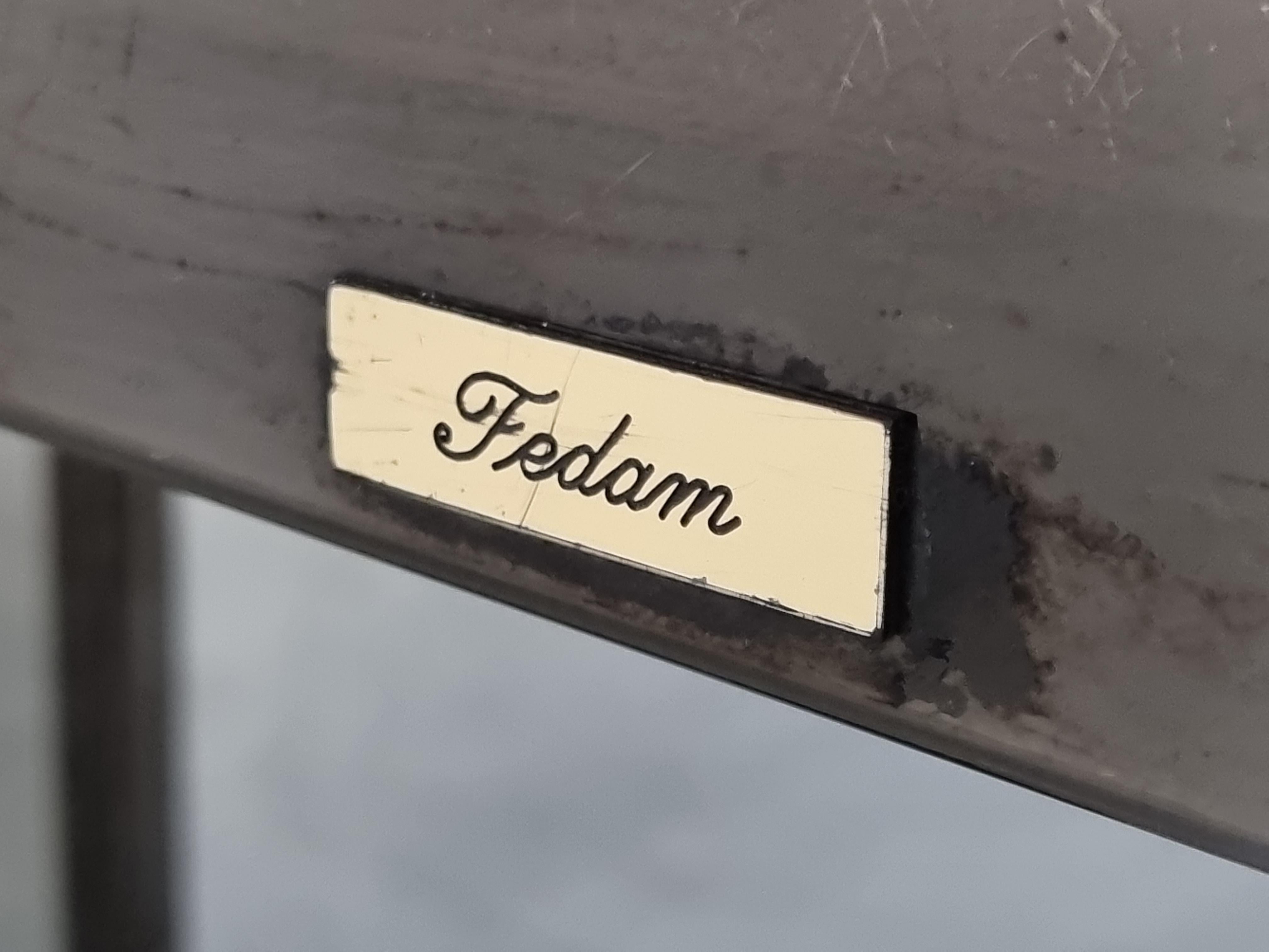 Unique coffee table that, with a twist of the knob, reveals a hidden bar compartment.

The coffee has a brass and mirrored glass base with a granite and lacquered top.

Very good condition

Labeled Fedam

1980s - Belgium

Dimensions: