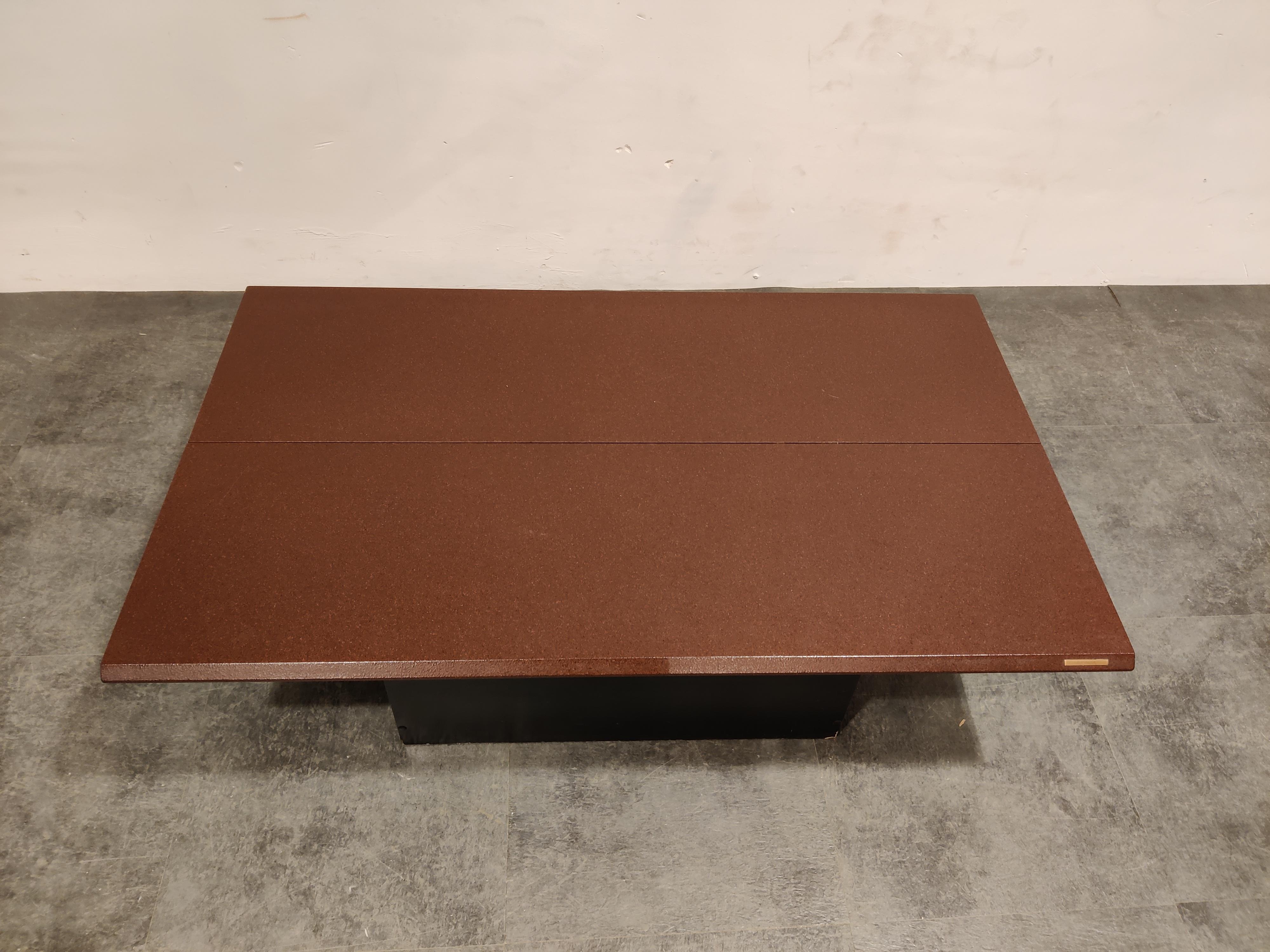 Eye catching coffee table with a hidden bar compartment.

The table consists of two red/bordeaux coloured wooden table tops and a black wooden base.

One top slides open whilst the other table top elevates revealing a bar compartment.

Nice