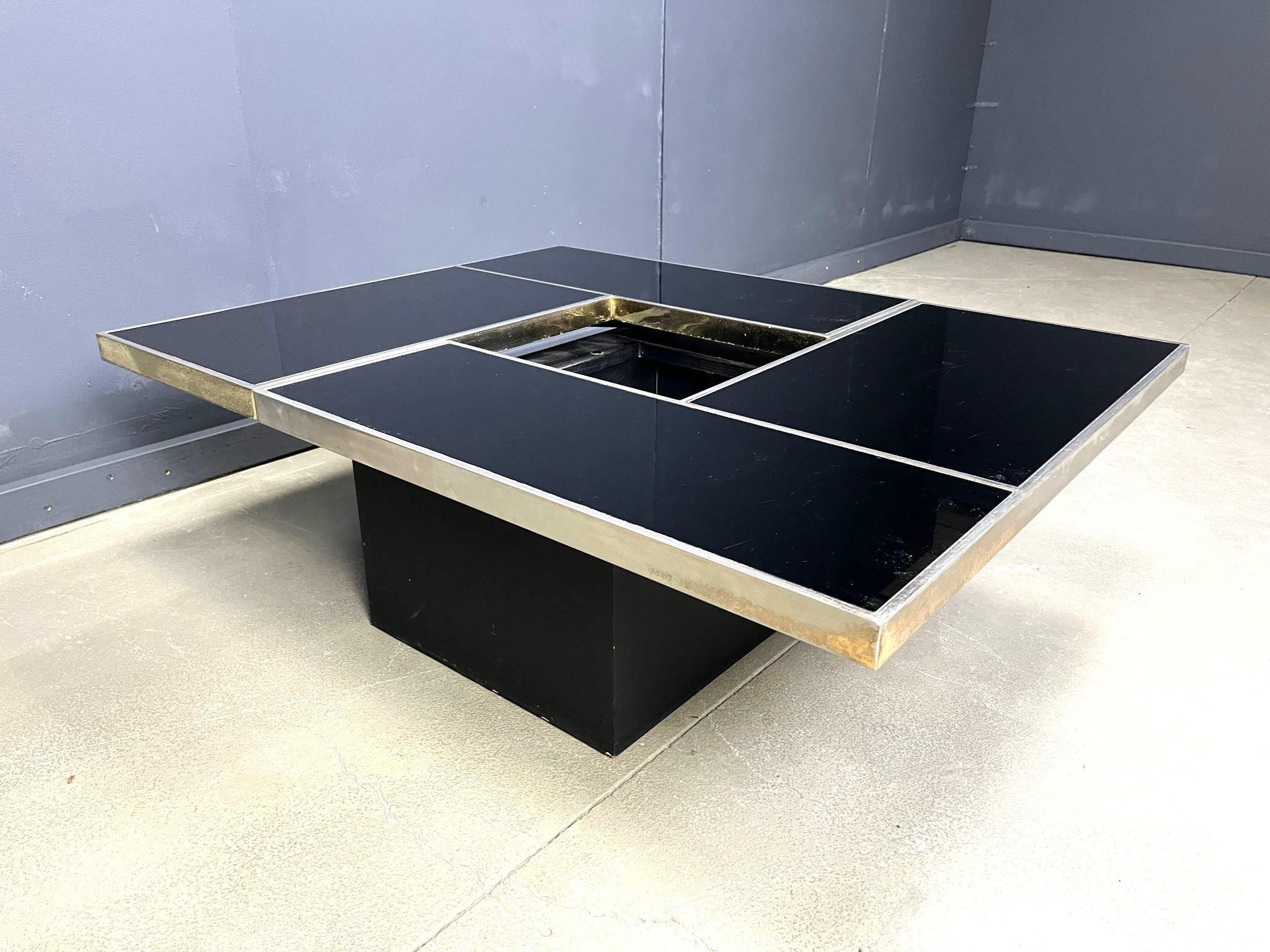 
Versteckter Bar-Couchtisch, der Willy Rizzo zugeschrieben wird.

Dieser Couchtisch besteht aus zwei schwenkbaren Tischplatten, die sich öffnen lassen, um ein Getränkefach mit originellen Flaschenhaltern zu präsentieren.

Hergestellt aus Metall und