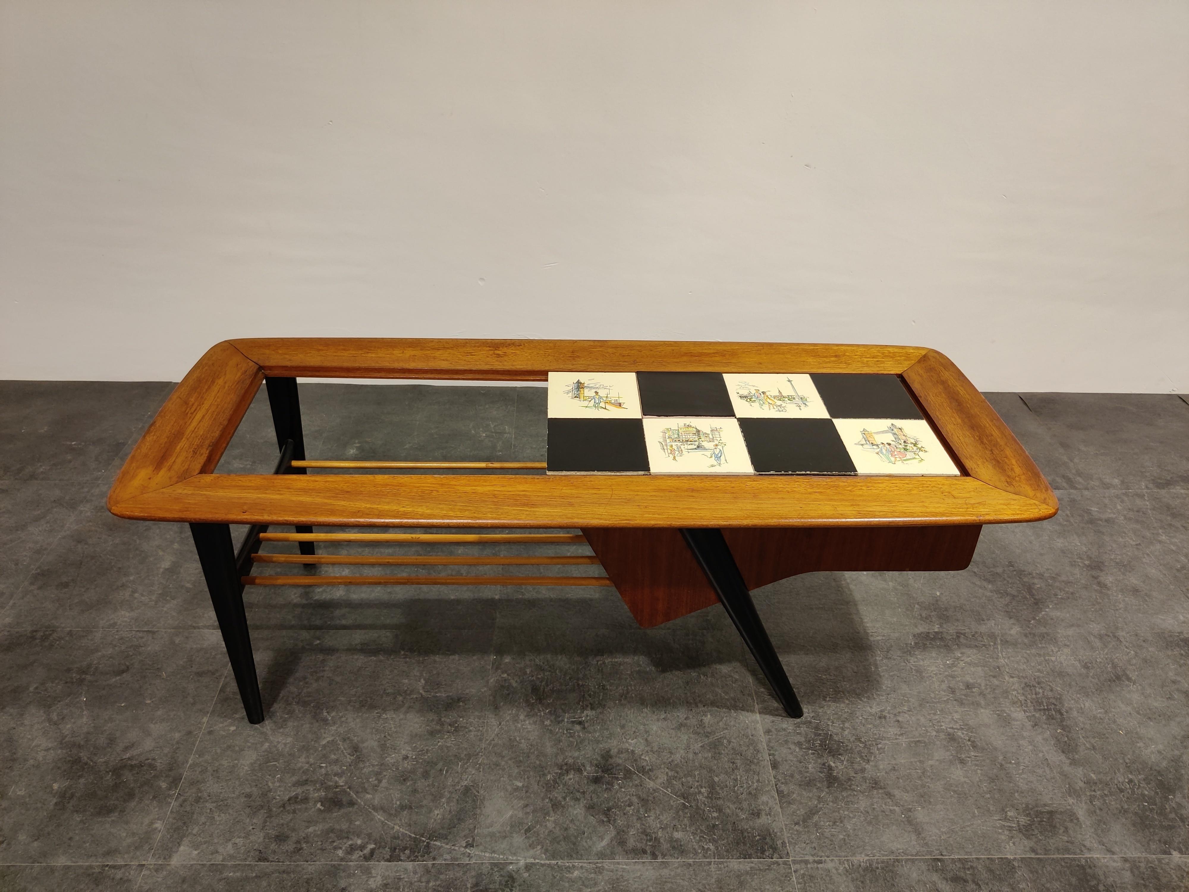 Midcentury coffee table by the Belgian designer Alfred Hendrickx.

The table features a hidden bar compartment and a moveable ceramic tyle top with drawings.

Beautifully finished wooden top and black lacquered legs.

One of our favorite (Belgian)
