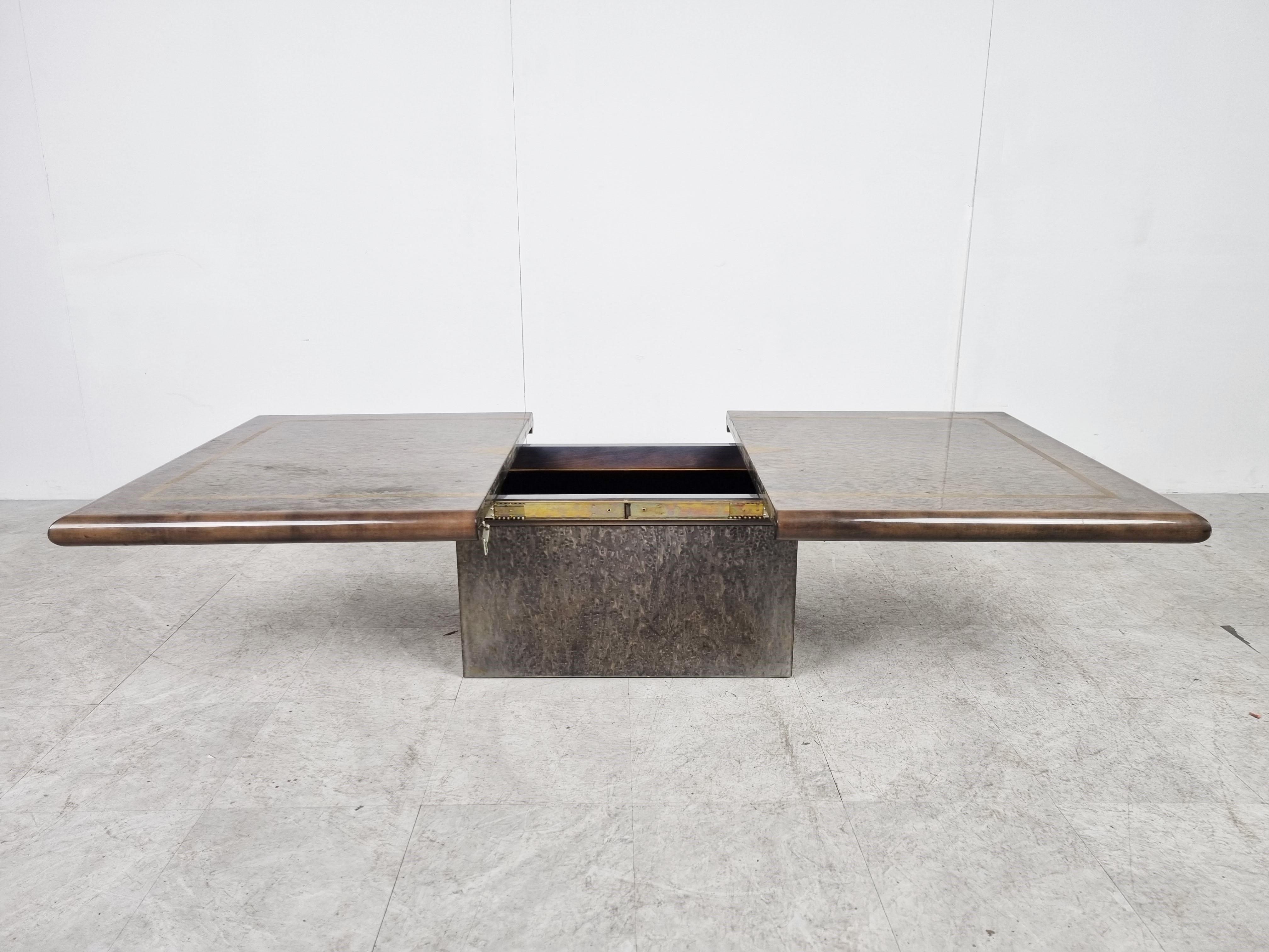 Exquisite wooden coffee table by Eric Maville.

This luxurious coffee table slides open to reveal a mirrored storage space for bottles and glass. 

Attractive lacquered wooden and inlaid brass top with a beautiful pattern and geometrical