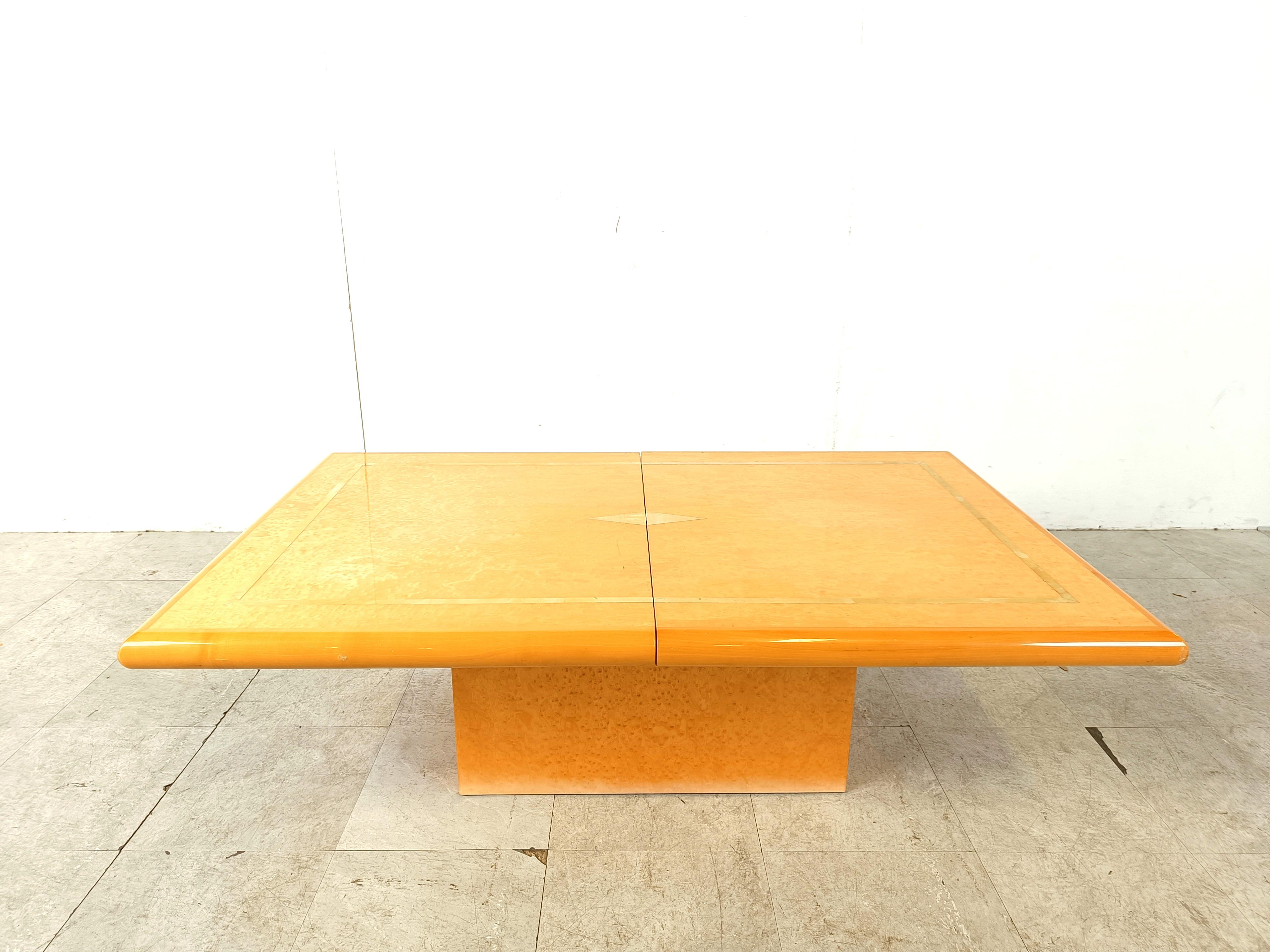 Exquise table basse en bois d'Eric Maville.

Cette luxueuse table basse s'ouvre en coulissant pour révéler un espace de rangement en miroir pour les bouteilles et les verres. 

Joli plateau en bois de placage, avec des gouttières en laiton