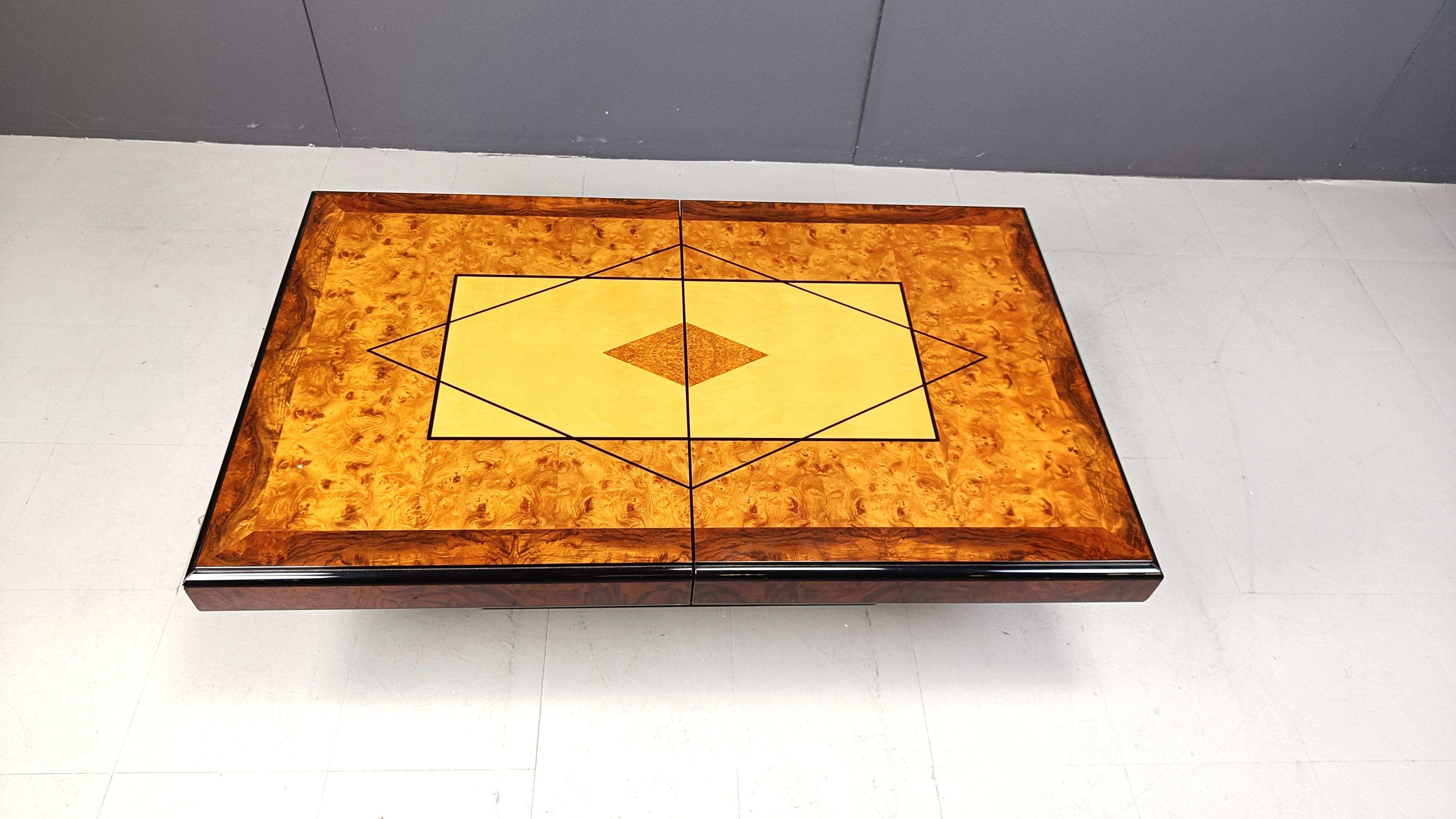 Exquisite wooden coffee table by Eric Maville.

This luxurious coffee table slides open to reveal a mirrored storage space for bottles and glass. 

Attractive veneer wooden top with a beautiful pattern and geometrical design.

Lacquered wooden