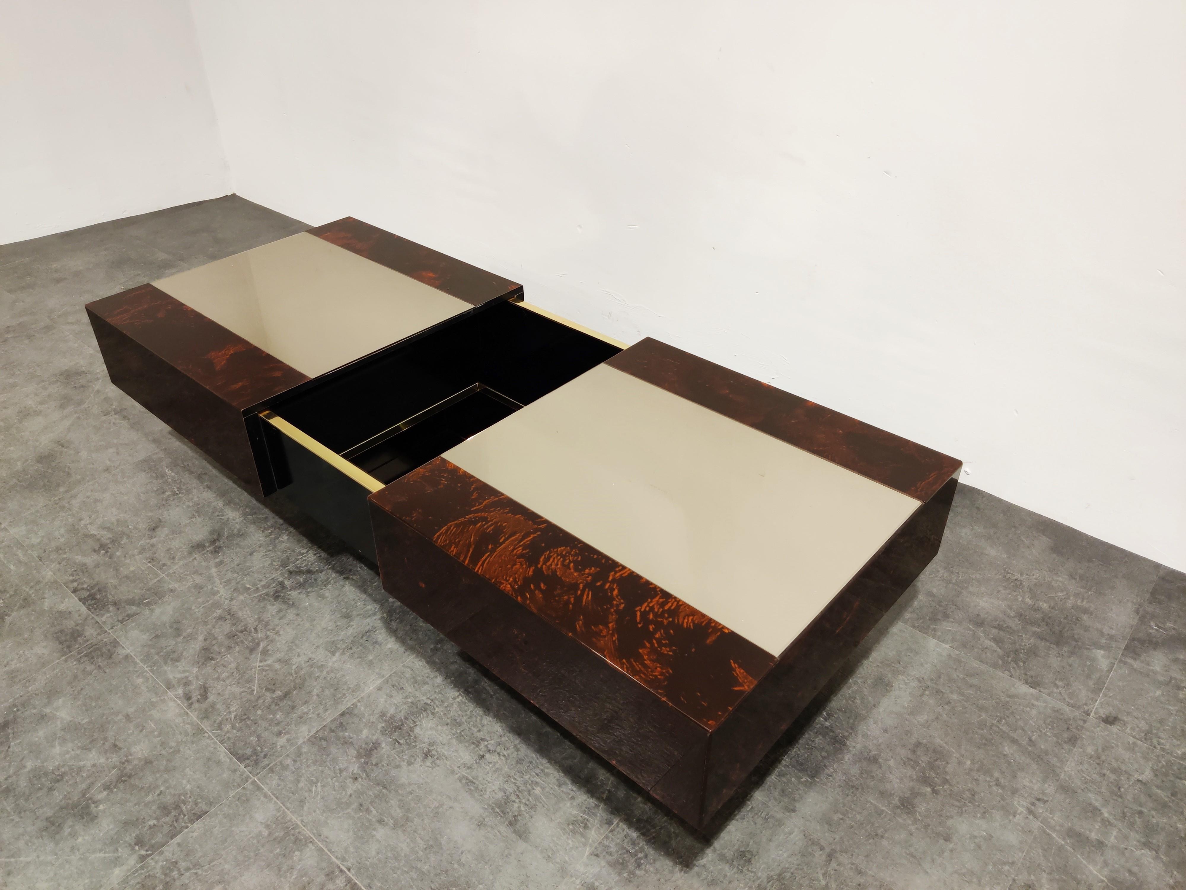 Lacquered wood coffee table by Eric Maville and Jean Claude Mahey.

This luxurious coffee table slides open to reveal a mirrored storage space for bottles and glass. If features a mirrored glass top and a lacquered wooden finish with beautiful
