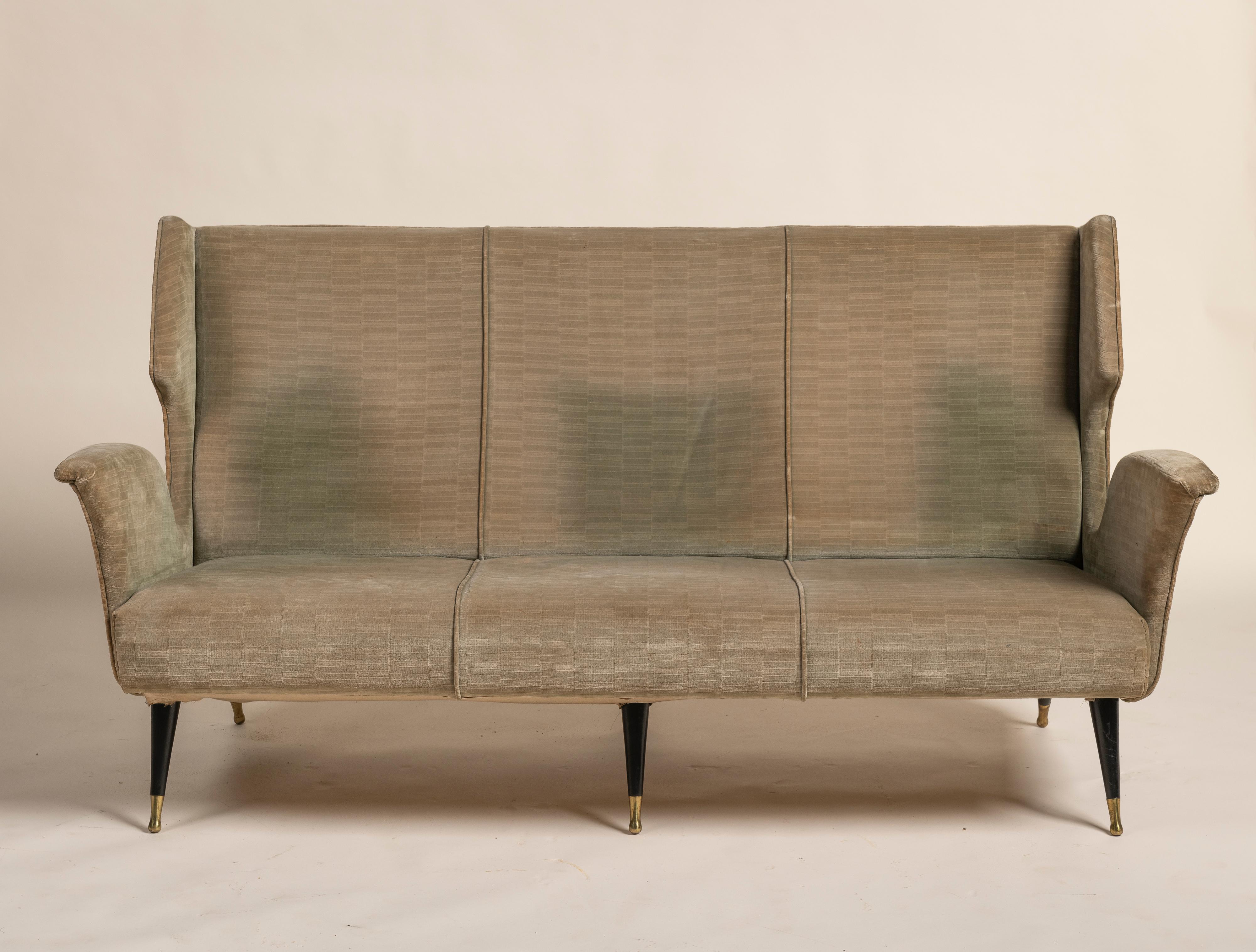 Canapé trois places classique du milieu du siècle dans le style de Gio Ponti, vers 1960. Cette pièce présente un dossier gracieusement incurvé se prolongeant par des accoudoirs pleins et ailés, le tout reposant sur quatre pieds fuselés en bois laqué