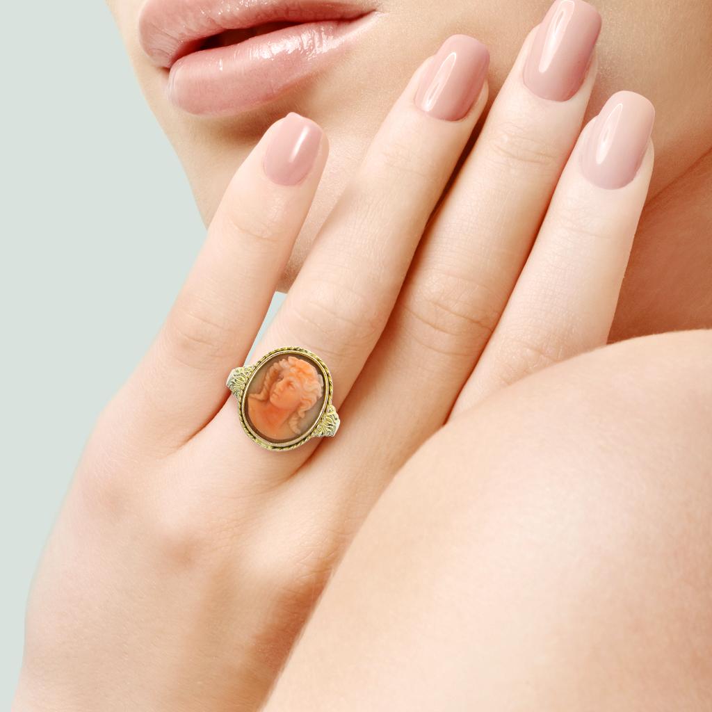 This vintage ring features a high relief carved coral portrait set into a 14K gold bezel set ring with accents on shoulders.

Hallmarks: 14K, 14K

Center Gemstone
Gemstone: Coral
Shape: Oval High Relief Cameo
Gemstone Measurements: 15 x
