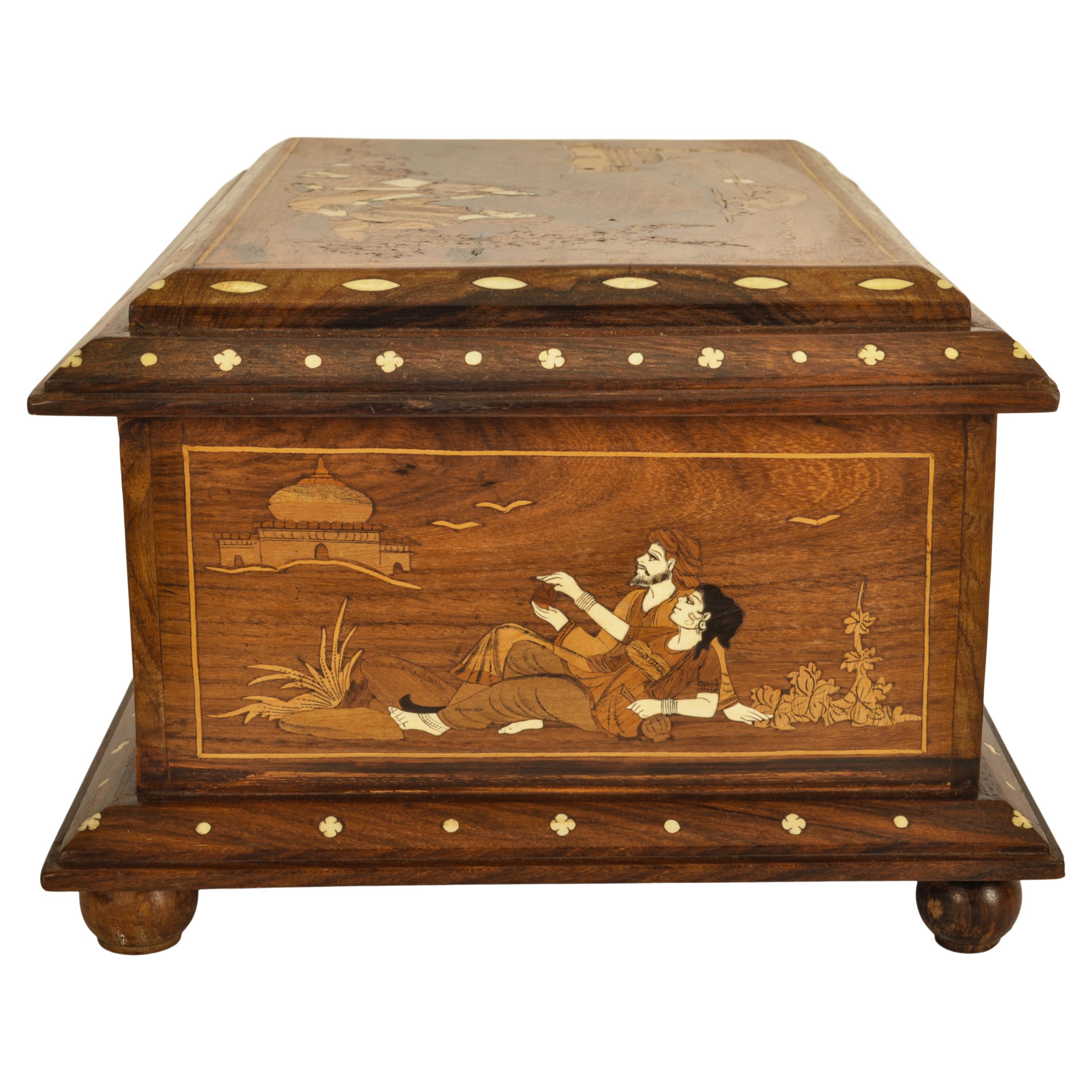 Une très belle boîte à bijoux indienne vintage en bois de rose marqueté. 
Le coffret à charnière est en palissandre massif figuré et finement incrusté d'os, d'ébène et de bois exotiques sur tous les côtés, représentant un Maharaja et une Maharani,