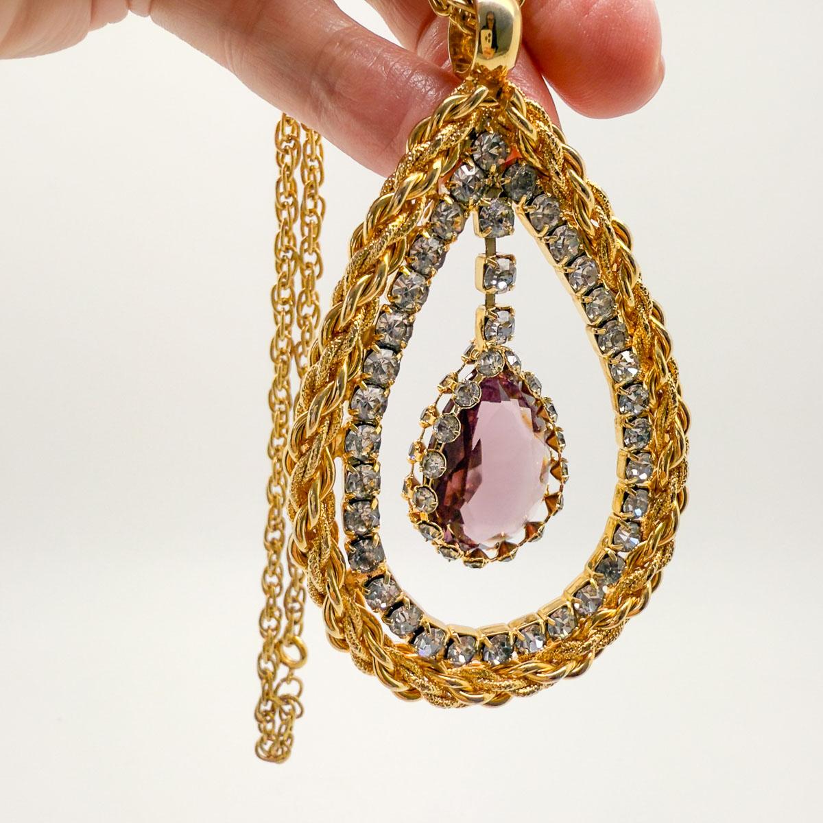 Un collier d'yeux en améthyste Hobé vintage des années 1960, dramatique et envoûtant. Longue et luxueuse, la chaîne à maillons de corde s'efface pour laisser place à un pendentif merveilleusement complexe et élégant. Avec des couches de corde en or,