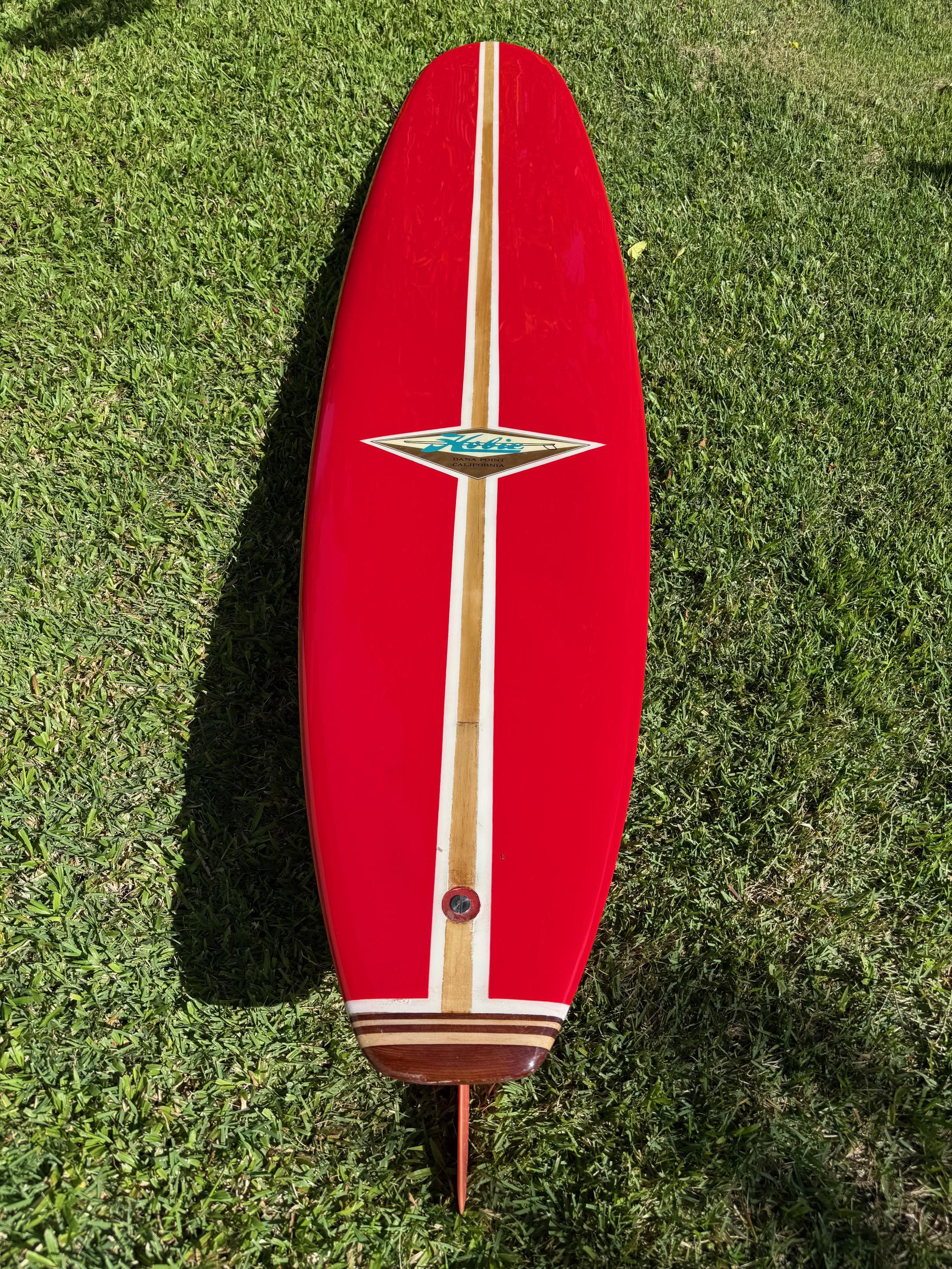 Vintage 1960s Hobie Surfboards klassisches Longboard. Ferrari-rote Verkleidung mit original Hobie-Flosse. Hobie Surfboards Dana Point Logo mit einem wunderschön gefertigten Holzschwanzblock. Ein erstklassiges Beispiel für ein klassisches Longboard