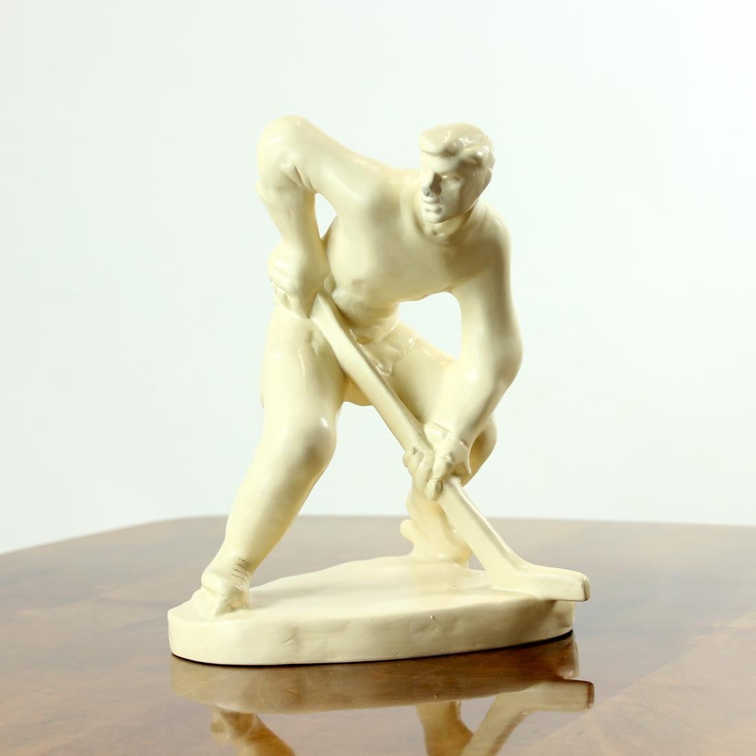 Beautiful and elegant statue of a hockey player. Produced by Jihokera in 1960s. The tature is marked by the designer Brada on the stand. The sculpture is produced out of off-white plaster with glazed top. Beautiful detailed work with details on the