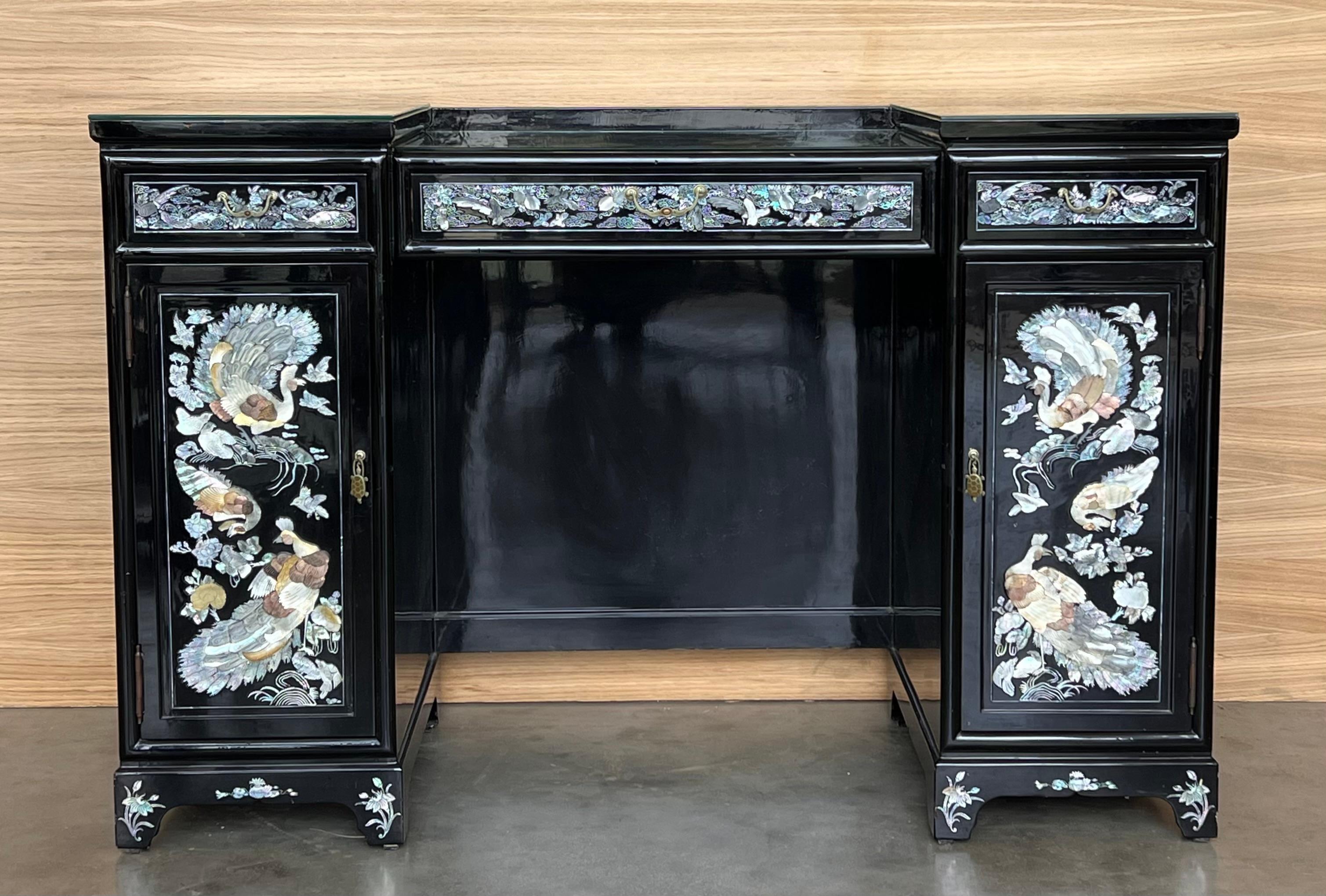 A vintage Regency black lacquered dressing table or desk with mirror. This large vanity features three spacious drawers, a marquetry top surface, diamond pattern detail extending through the drawer faces and on the side panels.
We have the matching