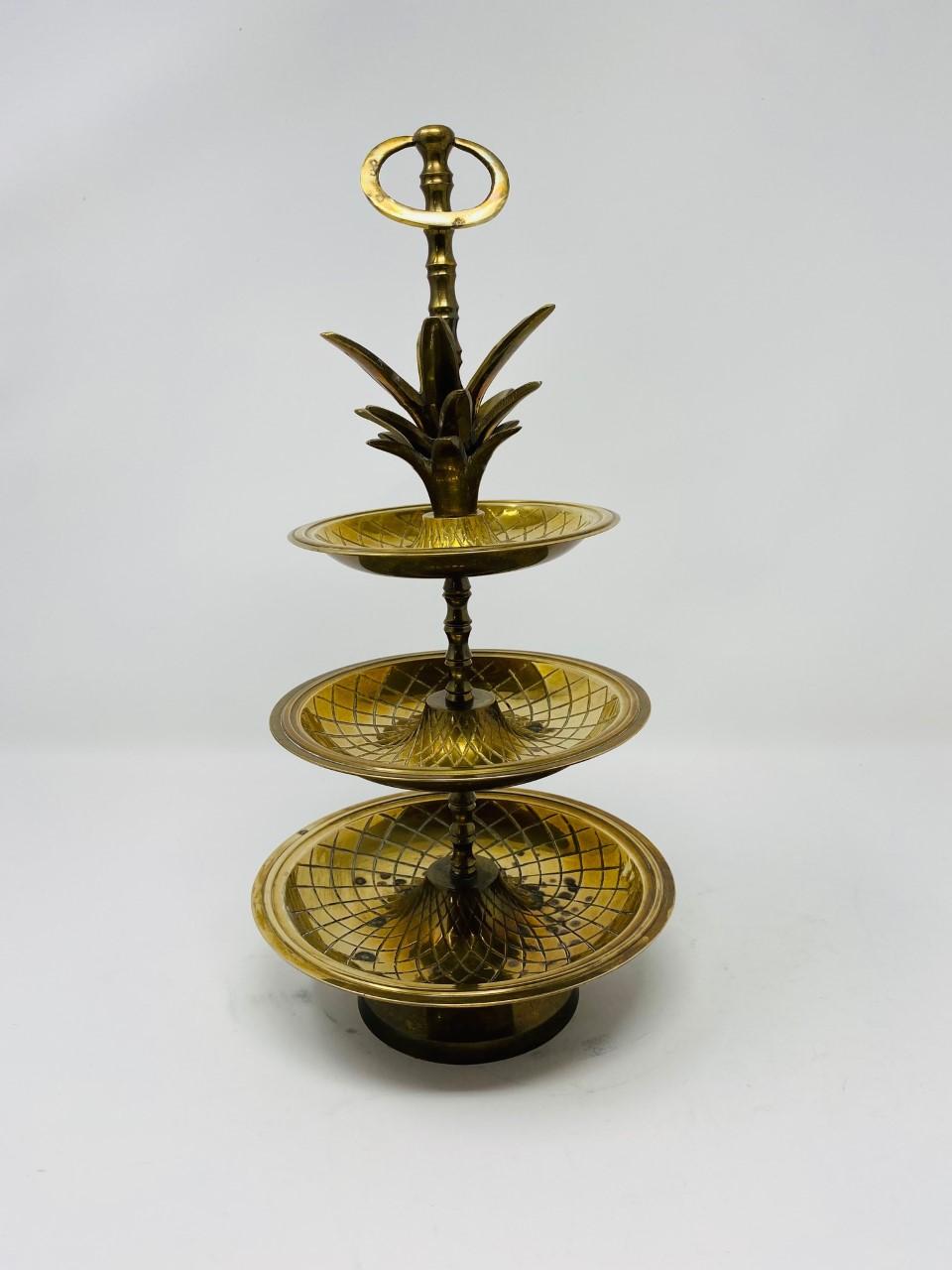Beautiful Hollywood Regency brass 3-tier pineapple nesting serving tray stand from the 1970s that is relevant, current and stylish. A glamorous addition to your bar or table escape or a signature piece full of chic for your vanity. Incredible piece