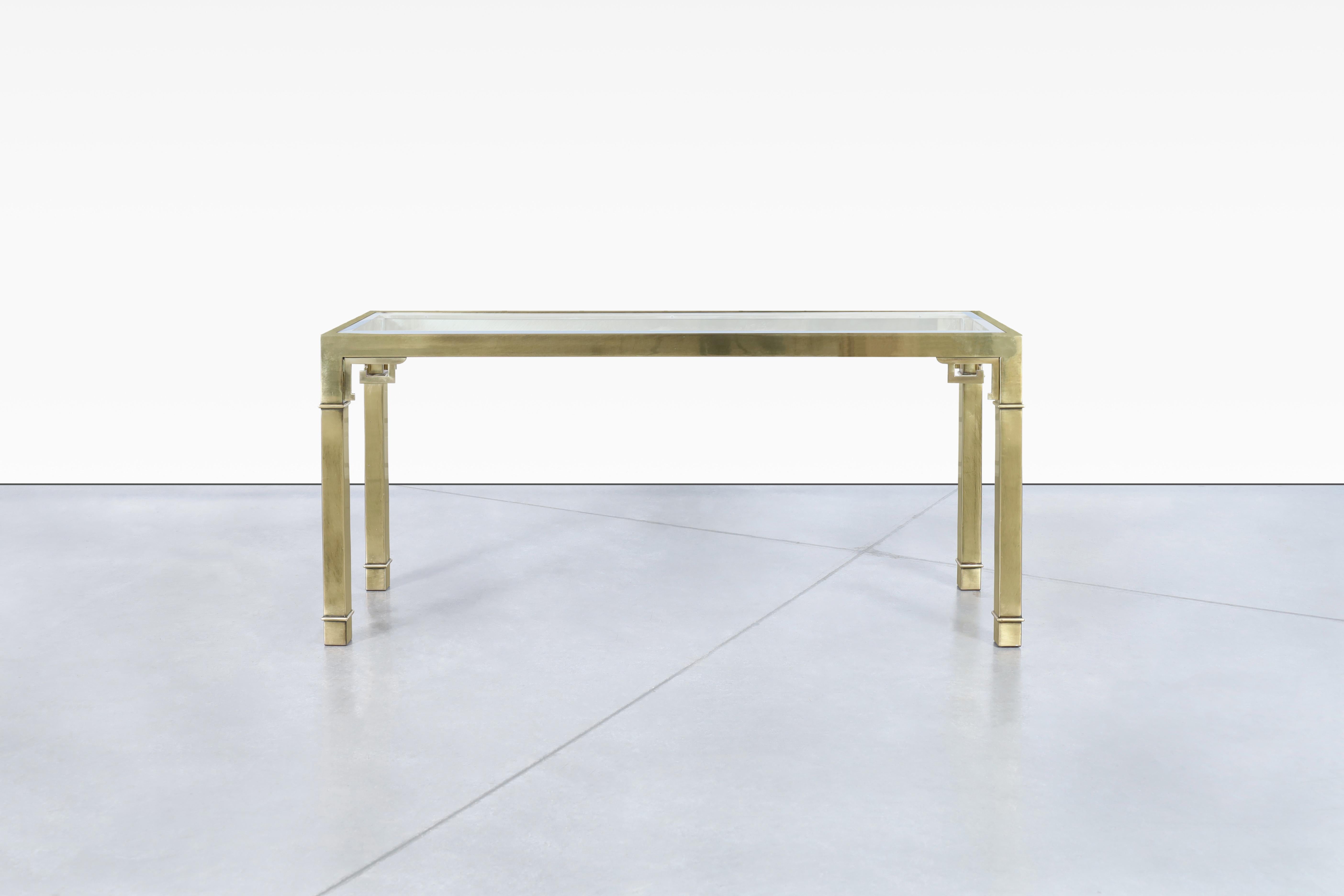 This vintage Hollywood Regency brass console table by Mastercraft is a true masterpiece of design. Crafted in the United States during the 1970s, this table features a patinated brass frame that exudes an air of elegance and sophistication. The