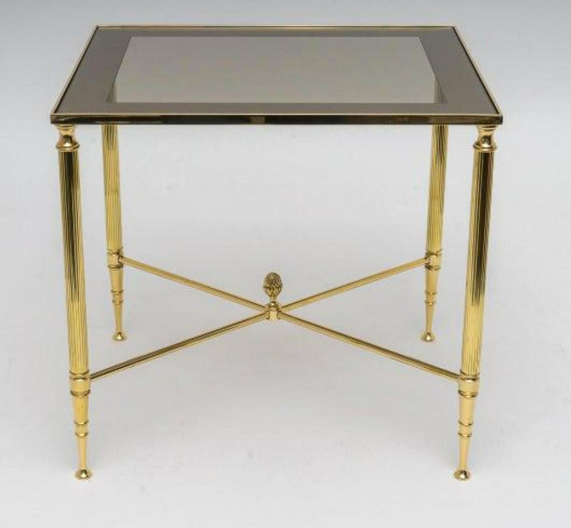 A beautiful set of three Hollywood Regency Nesting Tables attributed to Maison Jansen. All 3 are structurally sound and sturdy. Features fluted brass legs, smoked glass with mirrored edges (1.5