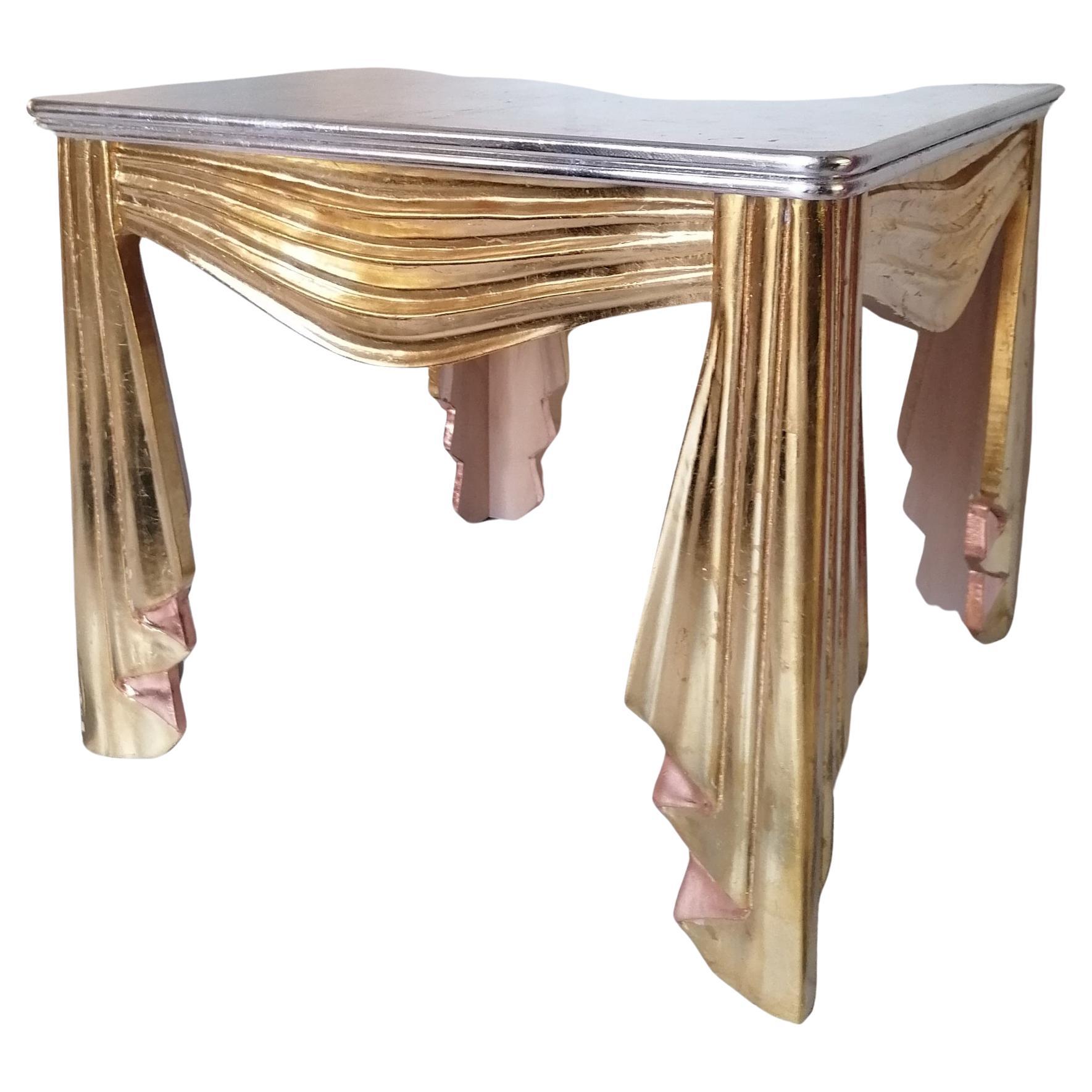 Table décorative en bois sculpté et doré de style Hollywood Regency, en forme de tissu froncé et ruché. Dessus en argent doré. USA, années 1960 / 1970. La finition est un peu vieillie par endroits, mais dans l'ensemble, elle est superbe.

Dimensions