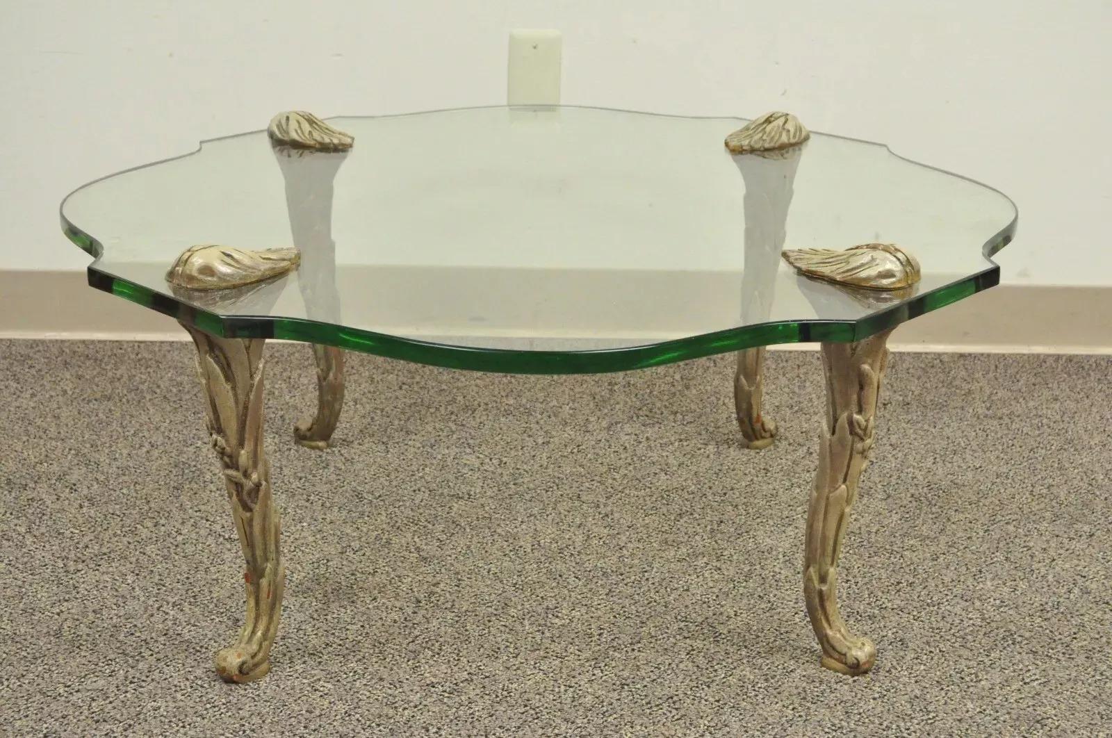 Table basse vintage Hollywood Regency en bois sculpté, pieds en Faux Bois, plateau en verre. A se caractérise par un plateau en verre façonné de 3/4