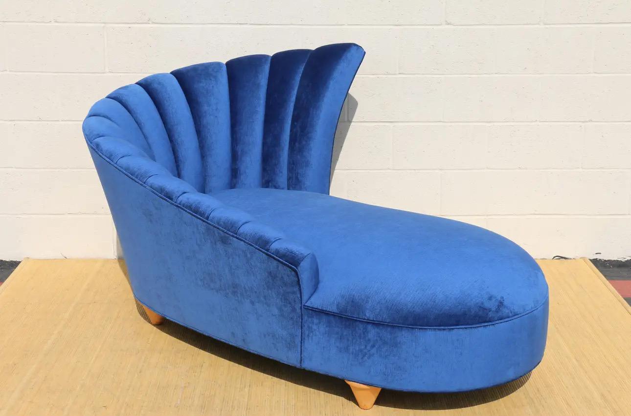 Étonnante chaise longue Hollywood Regency avec dossier en cannelure. Original des années 1970. Elle est en excellent état. Il a été retapissé dans un velours bleu. Et il a des pieds en bois. Une chaise absolument magnifique, confortable et robuste.