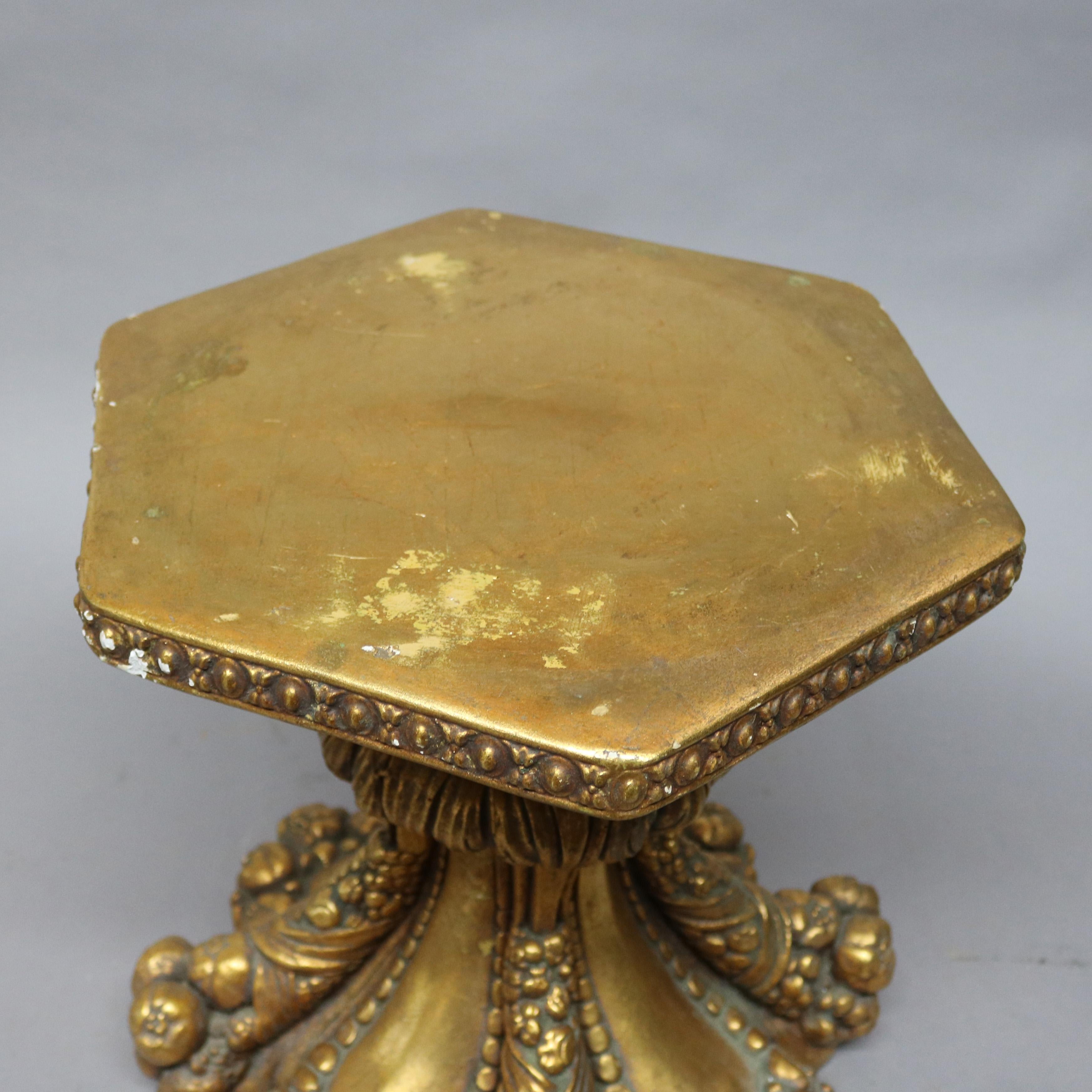 A vintage Hollywood Regency pedestal or side table offers gilt plaster construction with hexagonal top surmounting stylized cornucopia form base, circa 1950.

Measures - 16.5
