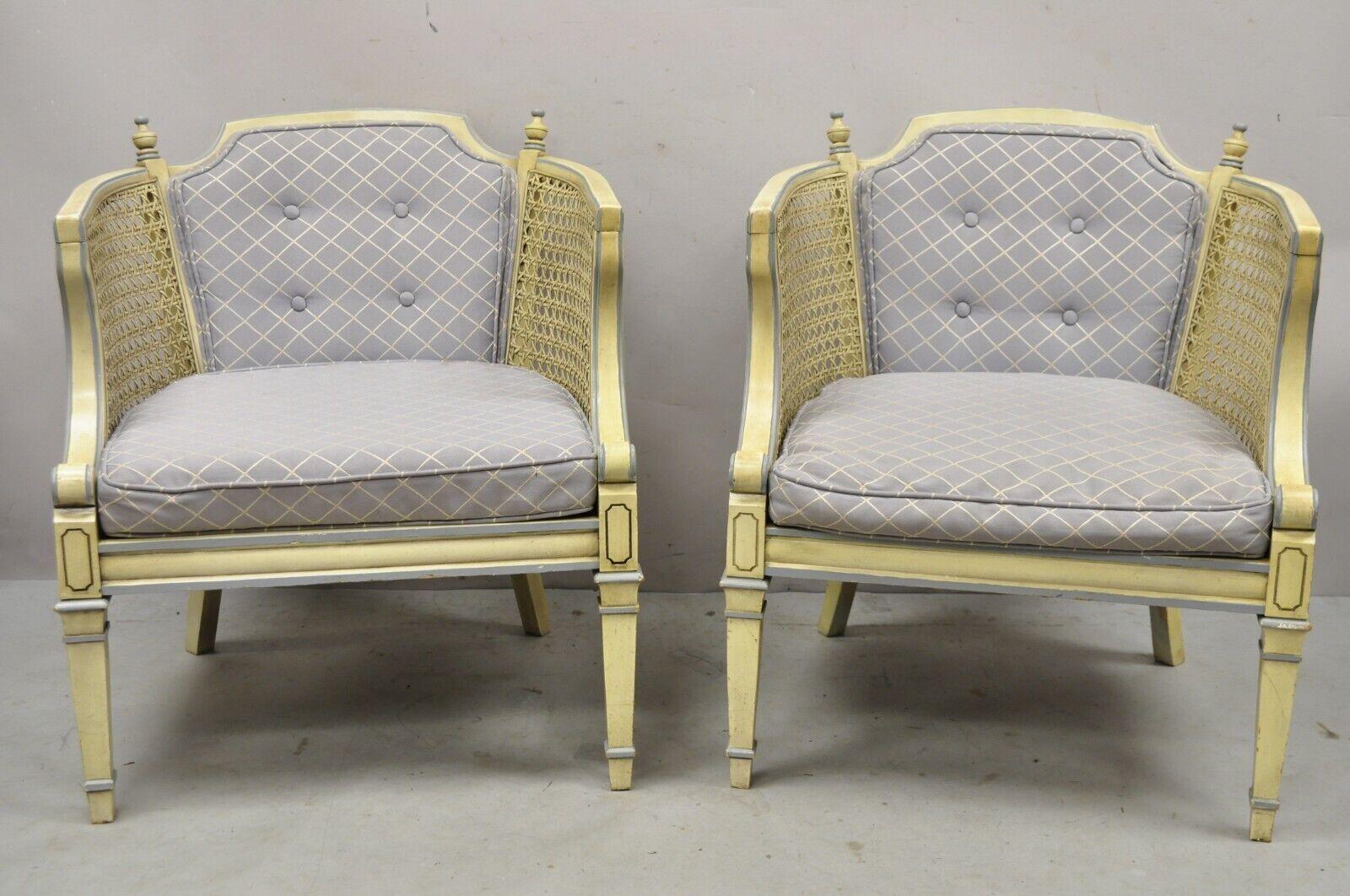 Vintage Hollywood Regency cream painted cane side club lounge chairs - a pair. Item features a cream painted finish, blue upholstery, cane panels, carved finials, solid wood frame, tapered legs, great style style and form. Circa late 20th century.