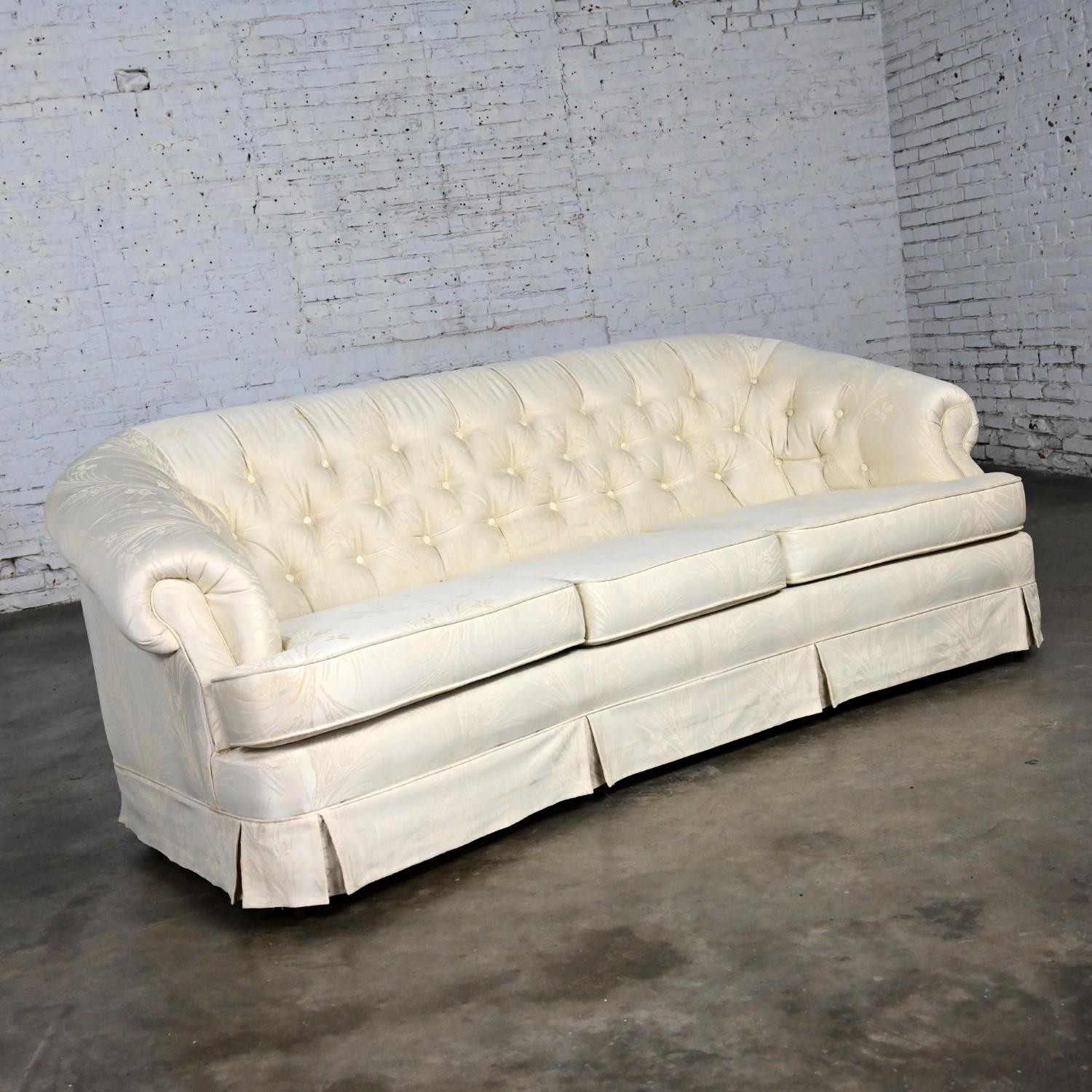 Marvelous vintage Hollywood Regency curved sofa with button tufted back, off white Damask fabric, three loose, zippered Dacron wrapped soft foam seat cushions, and round tapered wood feet. Beautiful condition, keeping in mind that this is vintage