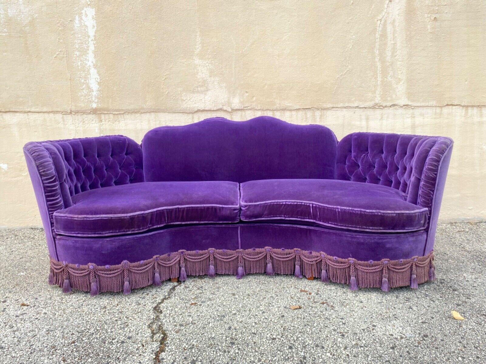 Vintage Hollywood Regency Custom Purple Mohair Serpentine Tassel Skirted Sofa. Original vintage custom made design, purple mohair fabric, shapely serpentine frame, tassel skirt all the way around, wooden legs, pleated and button tufted upholstery,