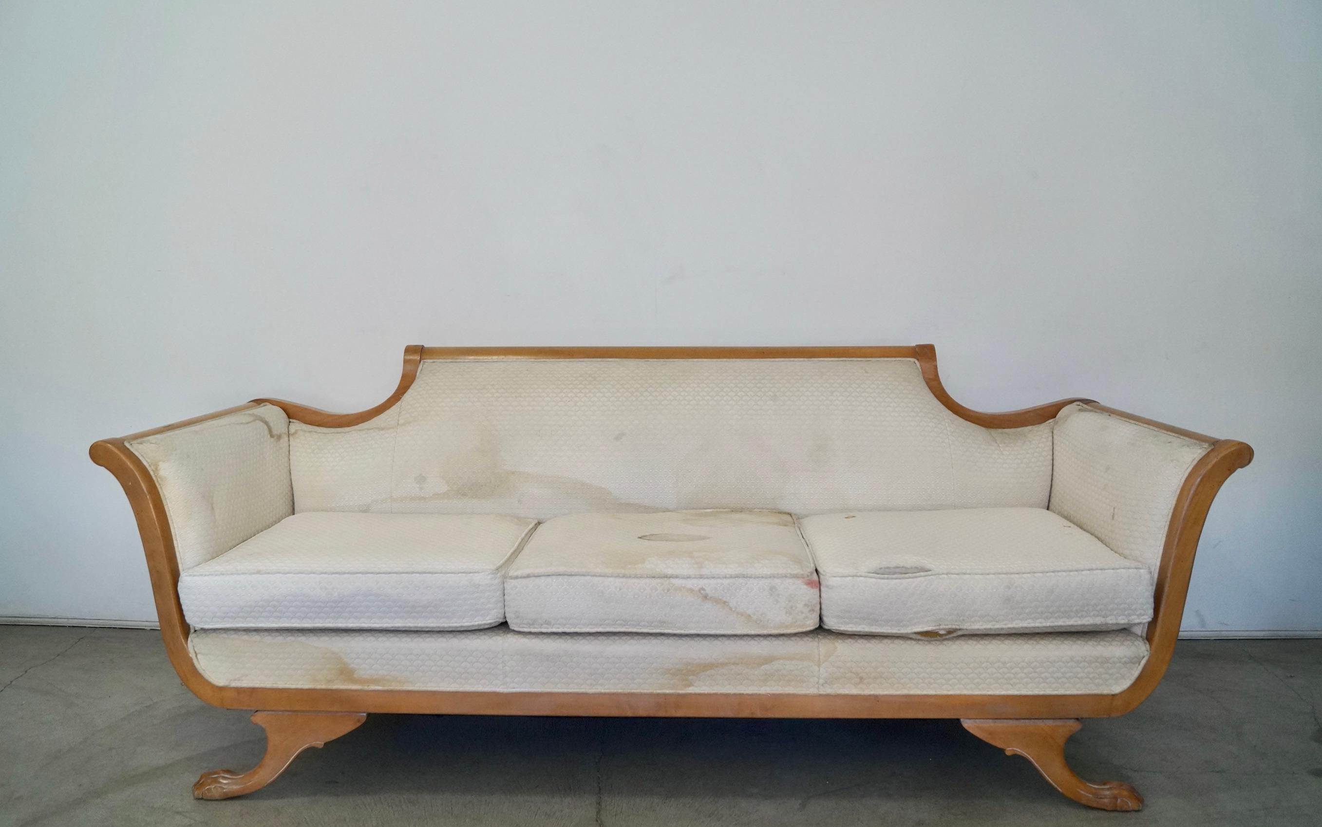 Vintage 1970's Hollywood Regency couch for sale. It has the original light wood finish. It's really well made, and has coil springs on the seatrest and springs on the backrest. It's structurally in excellent condition, and has a light wood finish.