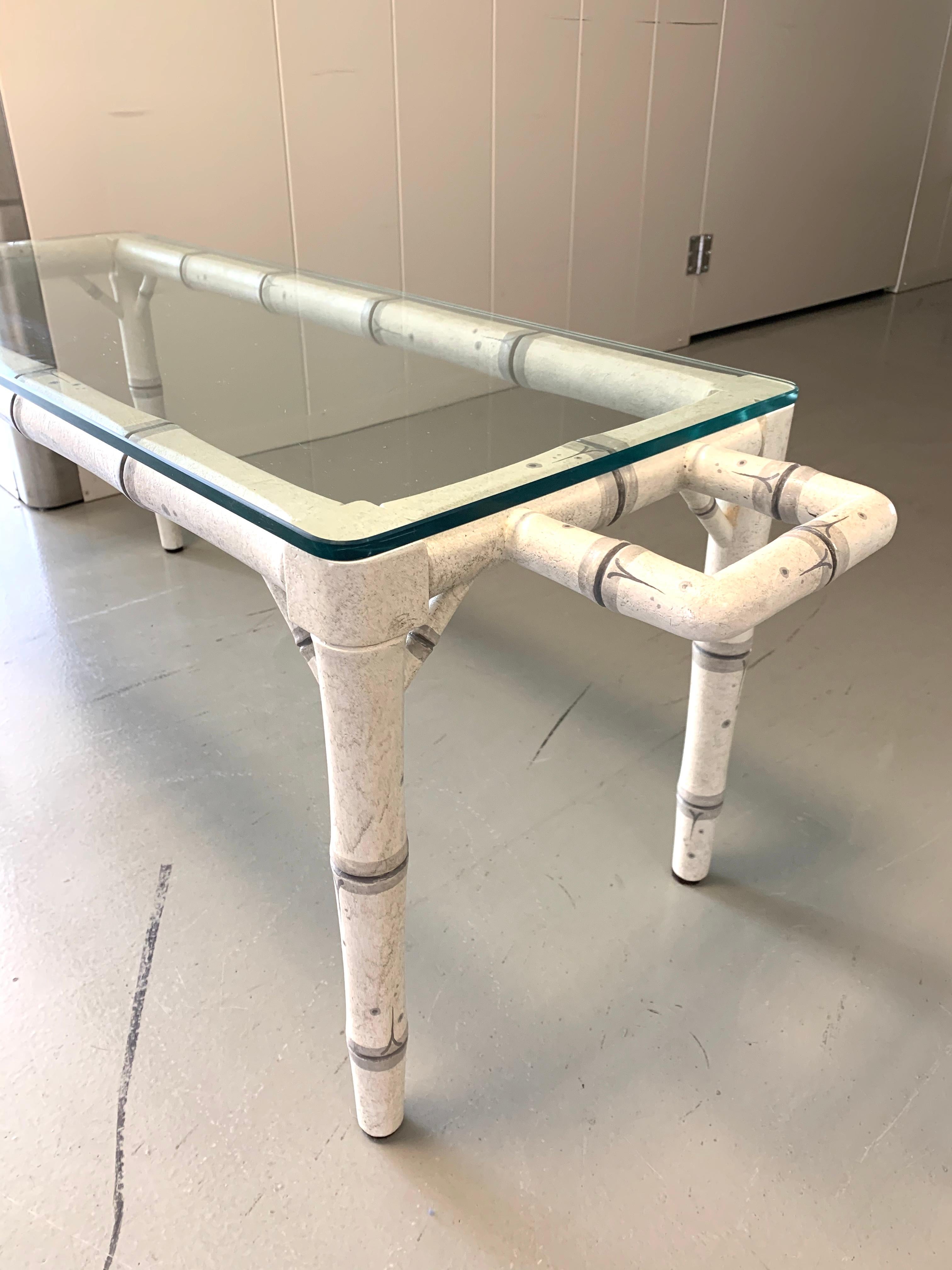 Esta mesa de centro vintage de imitación de bambú presenta una estructura de metal pintado diseñada para imitar la elegancia natural del bambú, rematada con una gruesa superficie de cristal. Los detalles pintados a mano añaden un carácter caprichoso