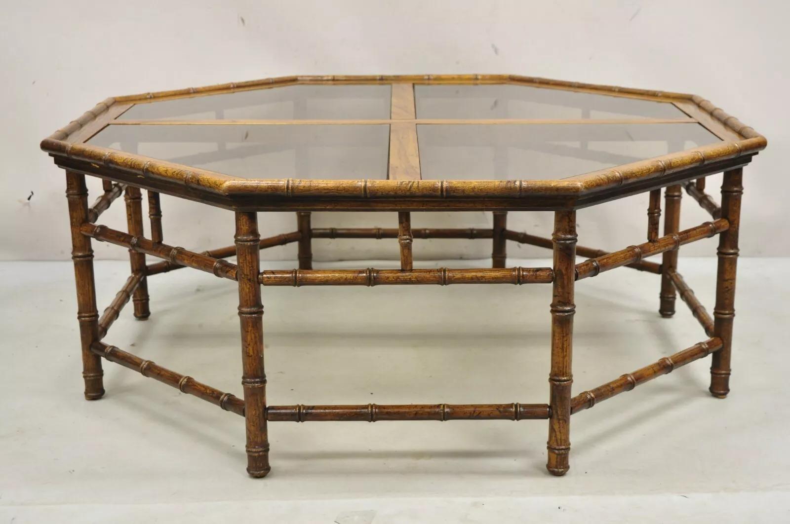 Table basse octogonale en faux bambou de style Vintage Hollywood Regency avec plateau en verre fumé à 4 panneaux et finition vieillie. Circa Late 20th Century. Dimensions : 17