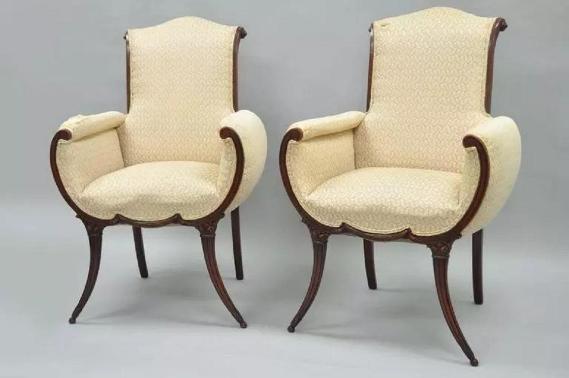 Pair of Hollywood Regency Mahogany Saber Leg Fireside Chairs Attributed to Grosfeld House. Item features shapely solid mahogany wood frames, rolled backs, with carved and tapered legs and front rail. The mahogany wood frame surrounds each chair