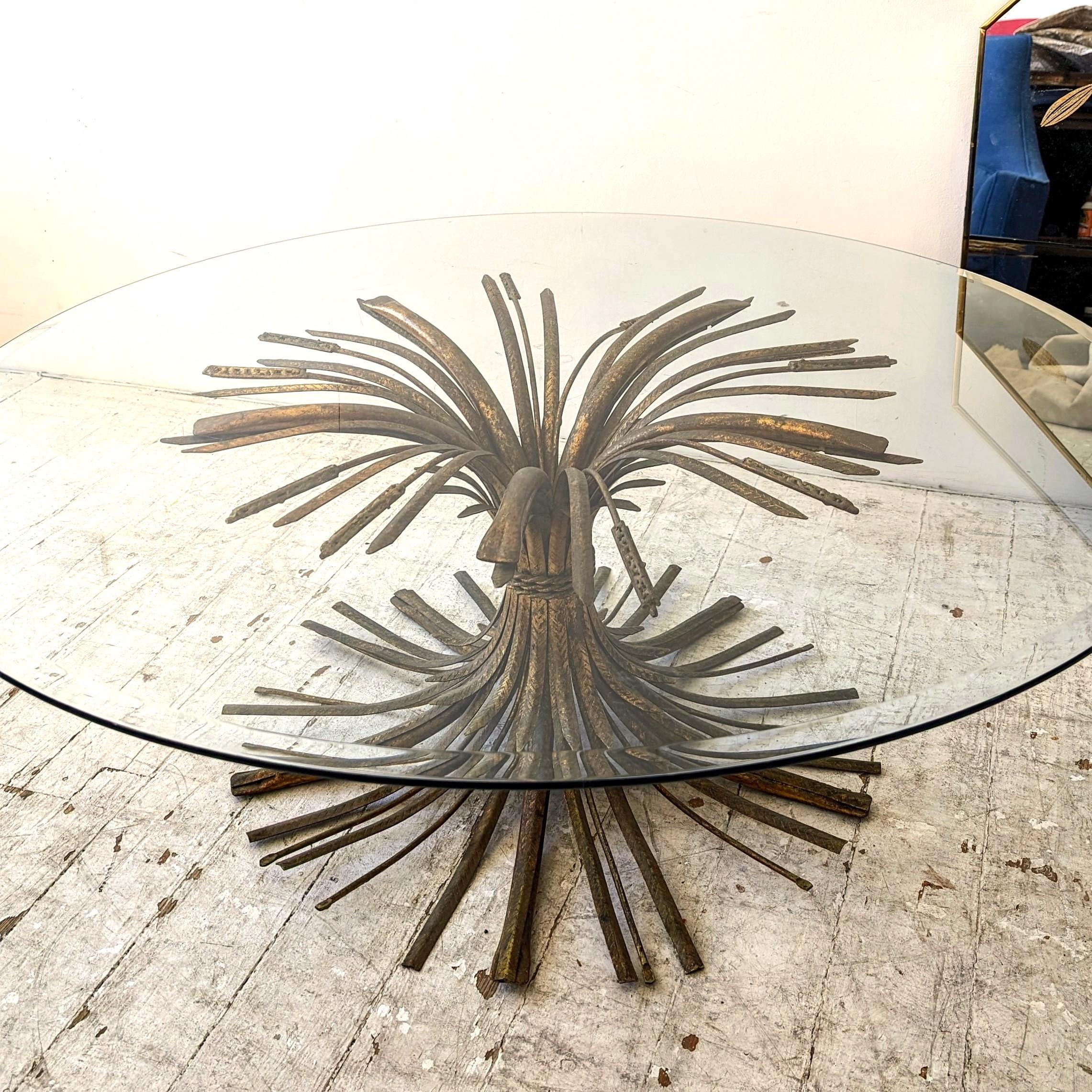 A large & voluminous Hollywood Regency gilt metal wheatsheaf 'Coco Chanel' coffee or centre table. Lots of age-related patina to the metal finish.
Bevelled glass top rests on top of the base.
c1960s.

Dimensions: diameter of glass top 114cm,