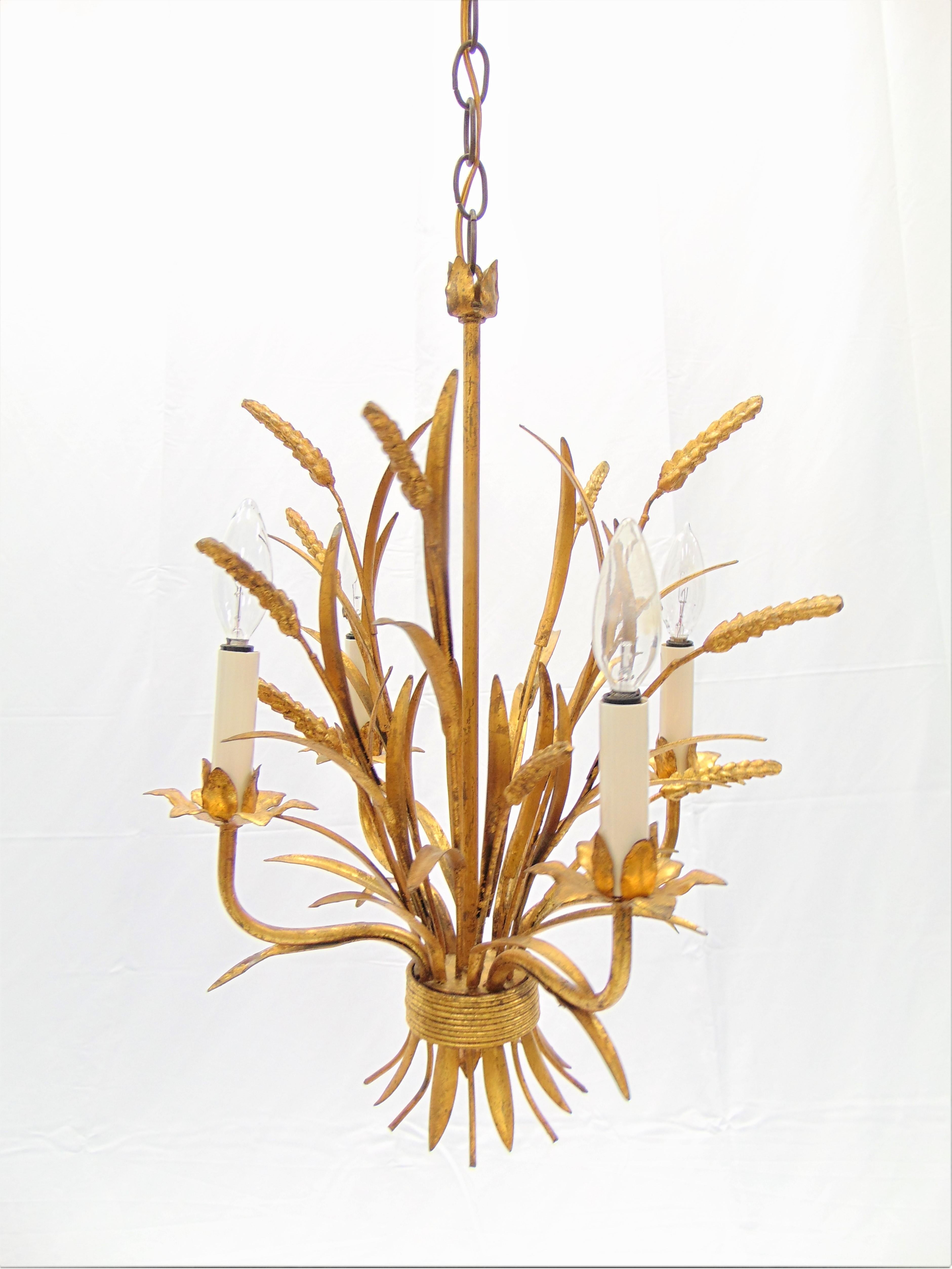 This is a beautiful vintage Hollywood Regency gold gilt Italian chandelier. The chandelier is from the 1960s and is perfect for a small room. This chandelier holds 4-light. It has the made in Italy metal tag attached. The dimensions are: 17”