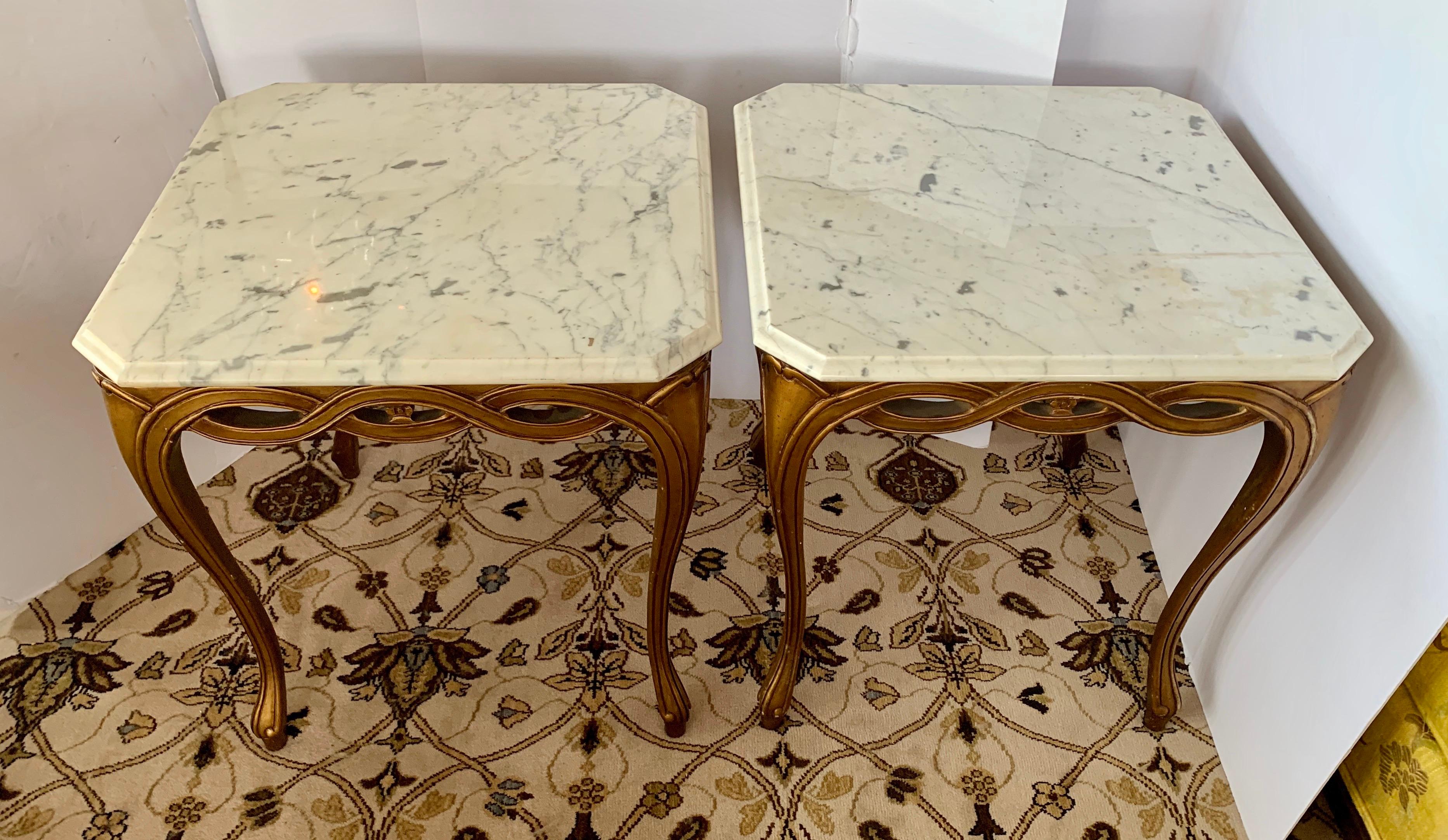 Elegant, sculptural matching pair of giltwood occasional tables with marble tops that are removable.
Gorgeous ribbon wood curves throughout apron on all sides. 