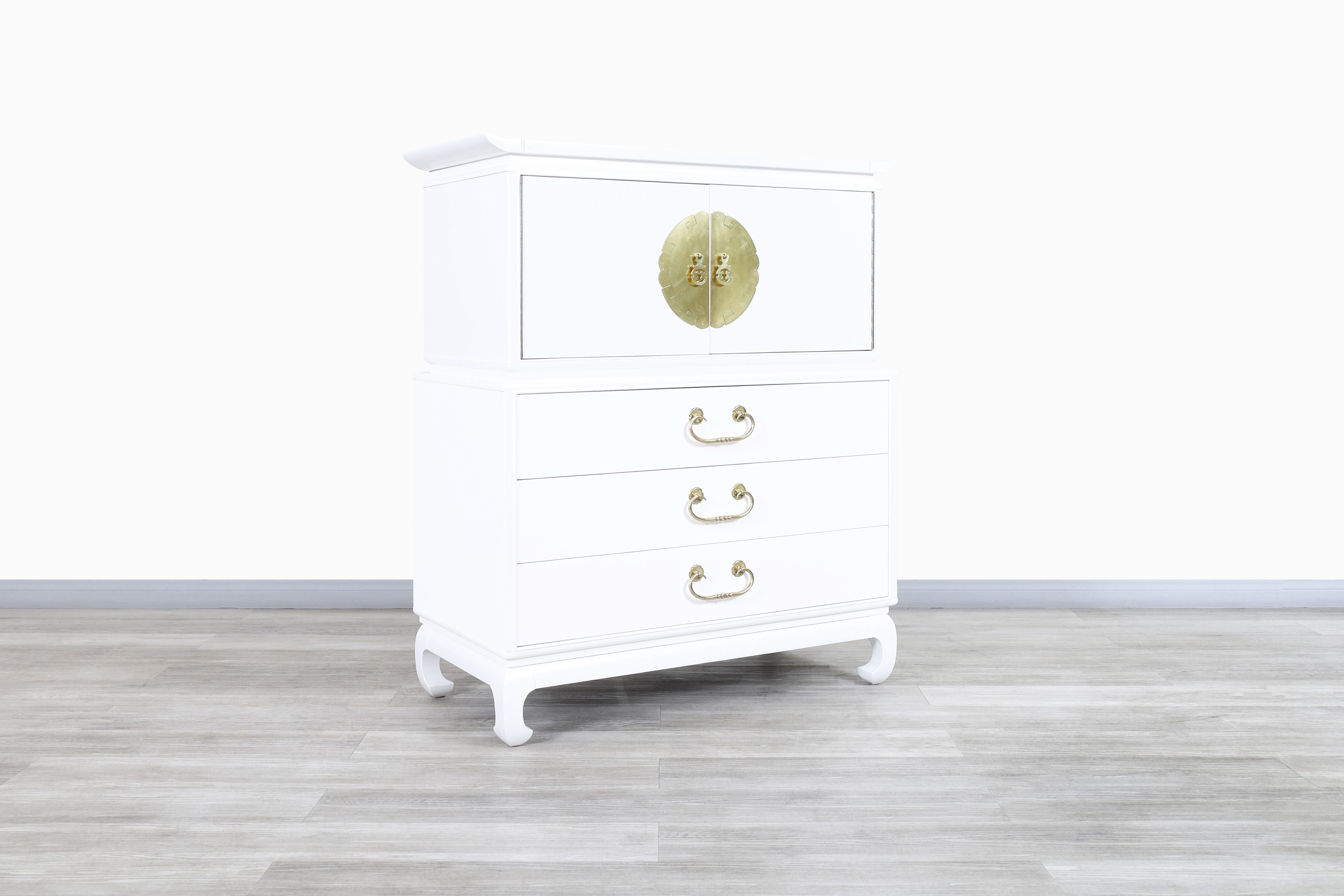 Wonderful vintage Hollywood Regency lacquered and brass highboy designed and manufactured in the United States, circa 1950s. This highboy has been professionally restored and features a polished white lacquer that powerfully signifies the elegance