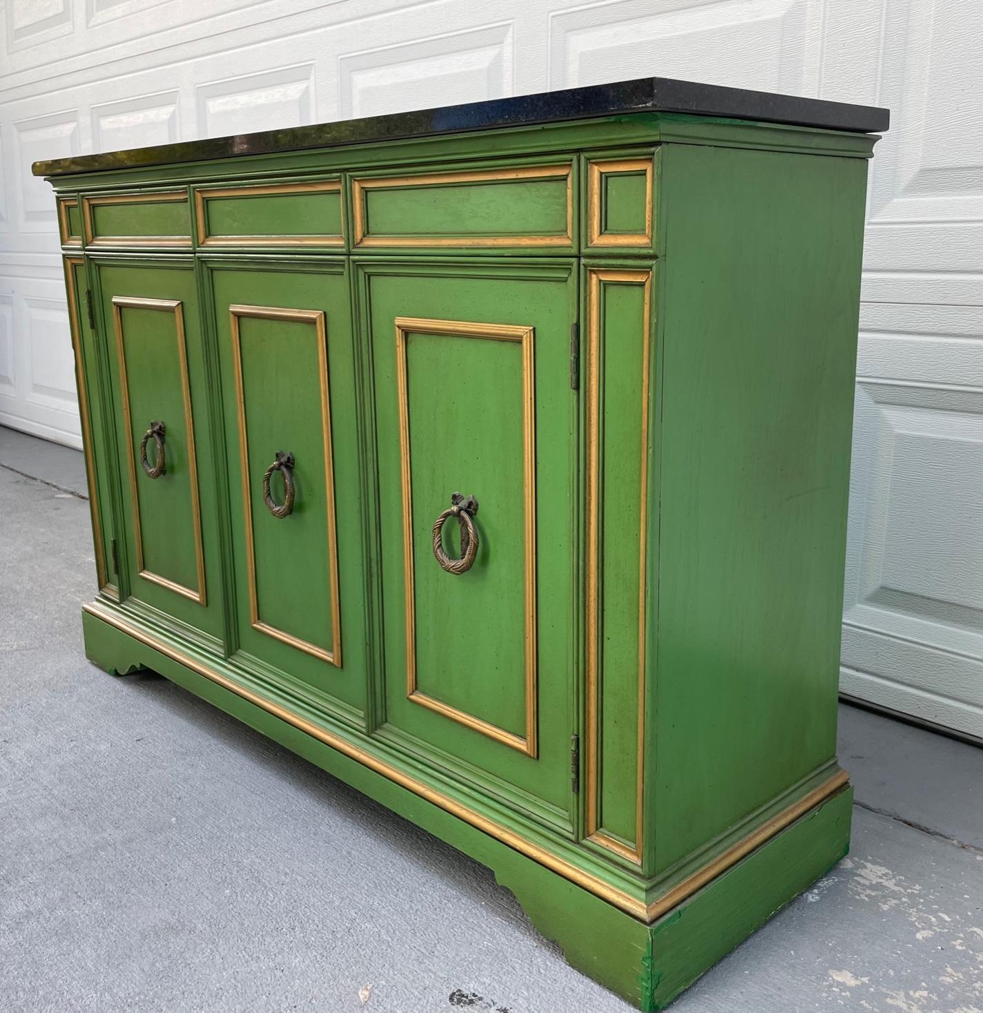 Vintage Hollywood Regency marble top emerald green credenza with gold accents.

Vintage Stylish Hollywood Regency low credenza is in the style of the German furniture designer, Tommi Parzinger. This fabulous Italian piece in vibrant emerald green