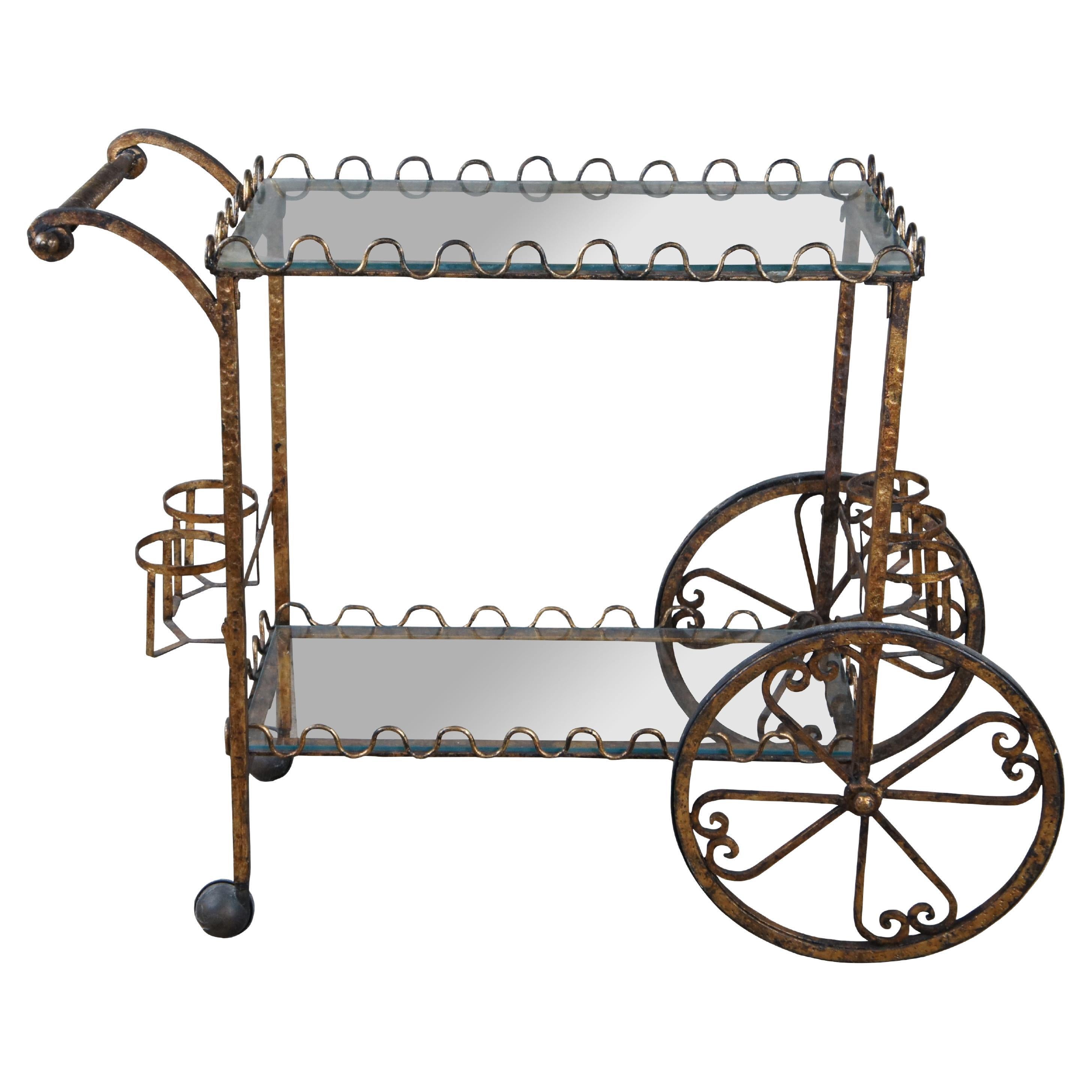 Carrito de bar neoclásico/regencia italiano vintage de hierro martillado y cristal, hacia la década de 1970.   Presenta dos superficies de cristal, una galería desplazable, 5 portabotellas y ruedas desplazables.  

Dimensiones:
17