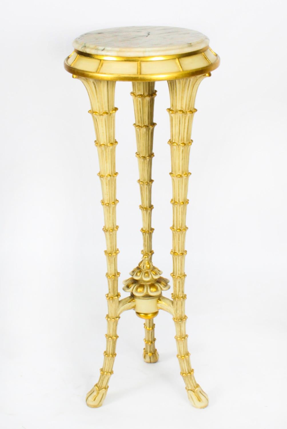 This is a gorgeous vintage Hollywood Regency cream and gilt painted white marble topped pedestal, circa 1950 in date.

The circular marble top is raised on tripod legs which are carved in the form of tapering palm tree trunks united with an 'x'